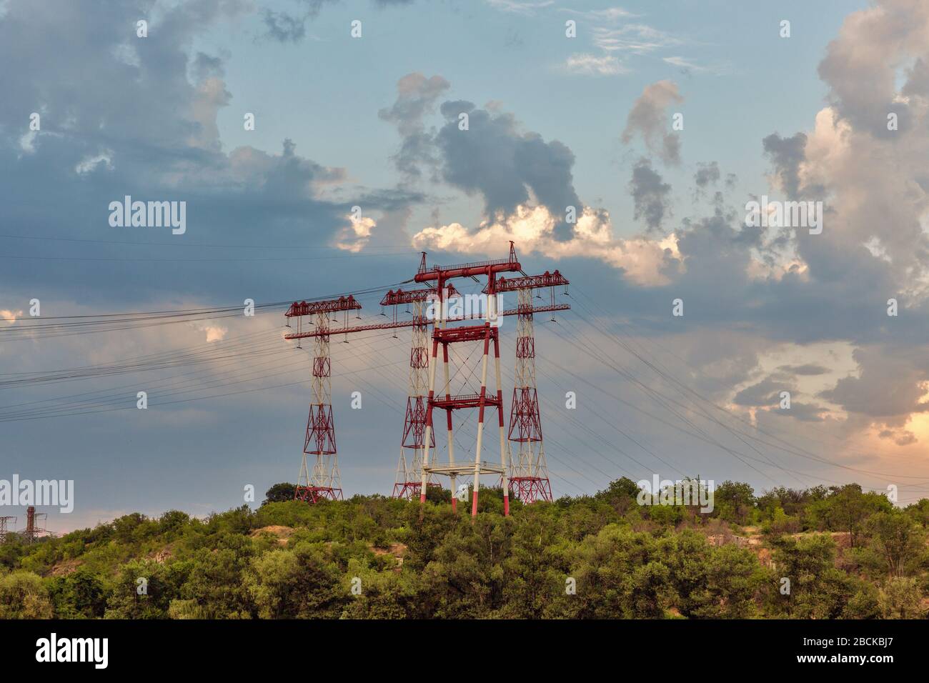 High voltage power lines towers at sunset on island of Khortytsia in Ukraine. Stock Photo