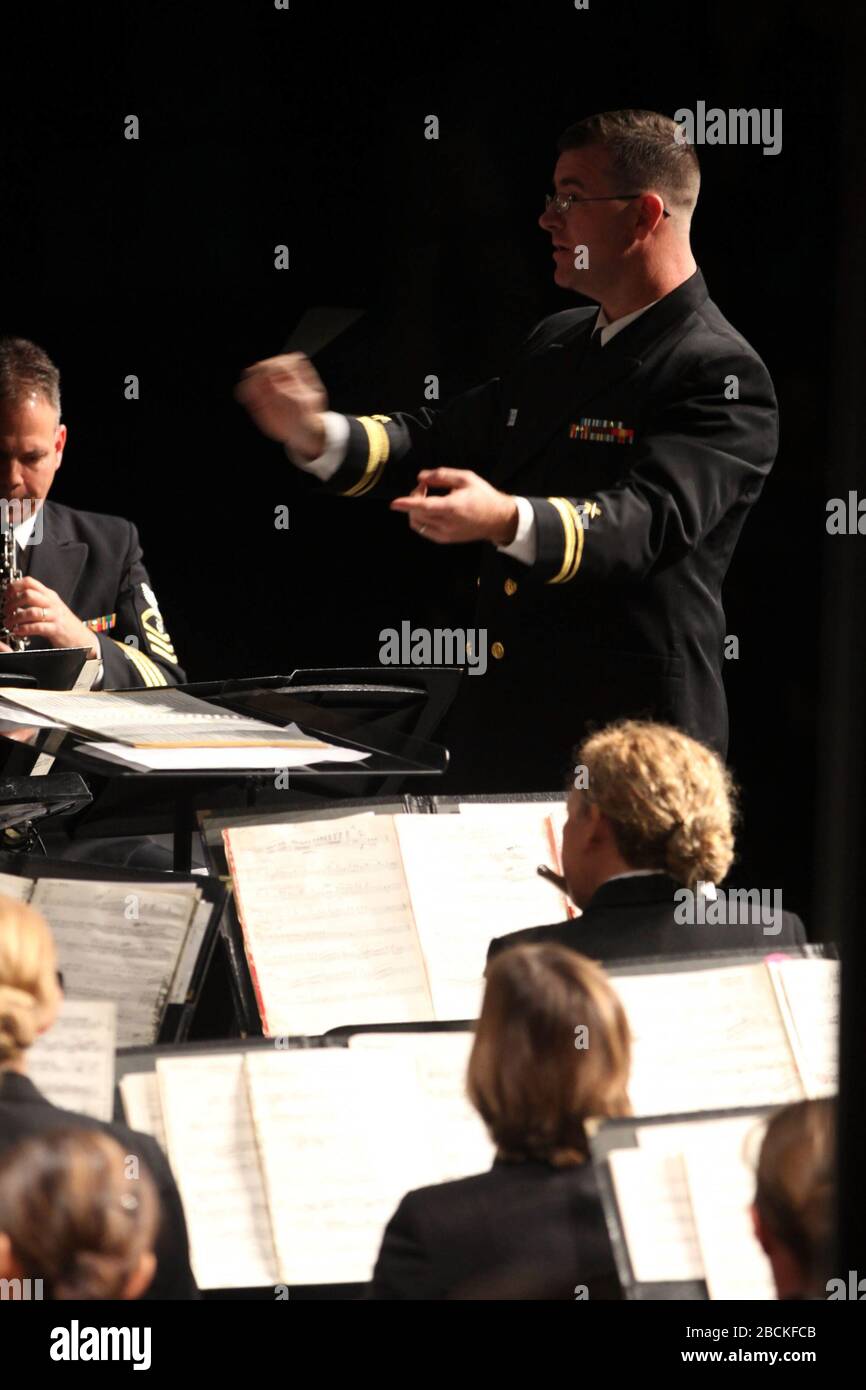 '131022-N-HG258-015 ASHBURN, VA (October 22, 2013) Lt. j.g. Bruce Mansfield, associate conductor with the United States Navy Band, directs the band during a daytime concert at Stonebridge H.S. in Ashburn, Va,. as part of it's Music in the Schools program. Music in the Schools is designed to supplement music education curricula and build bridges between the Navy and younger generations. (U.S. Navy Photo by MUC Stephen Hassay/Released); 23 October 2013, 10:53; Navy Band Music in the Schools at Stonebridge H.S. in Ashburn, Va.; United States Navy Band from Washington, D.C., USA; ' Stock Photo