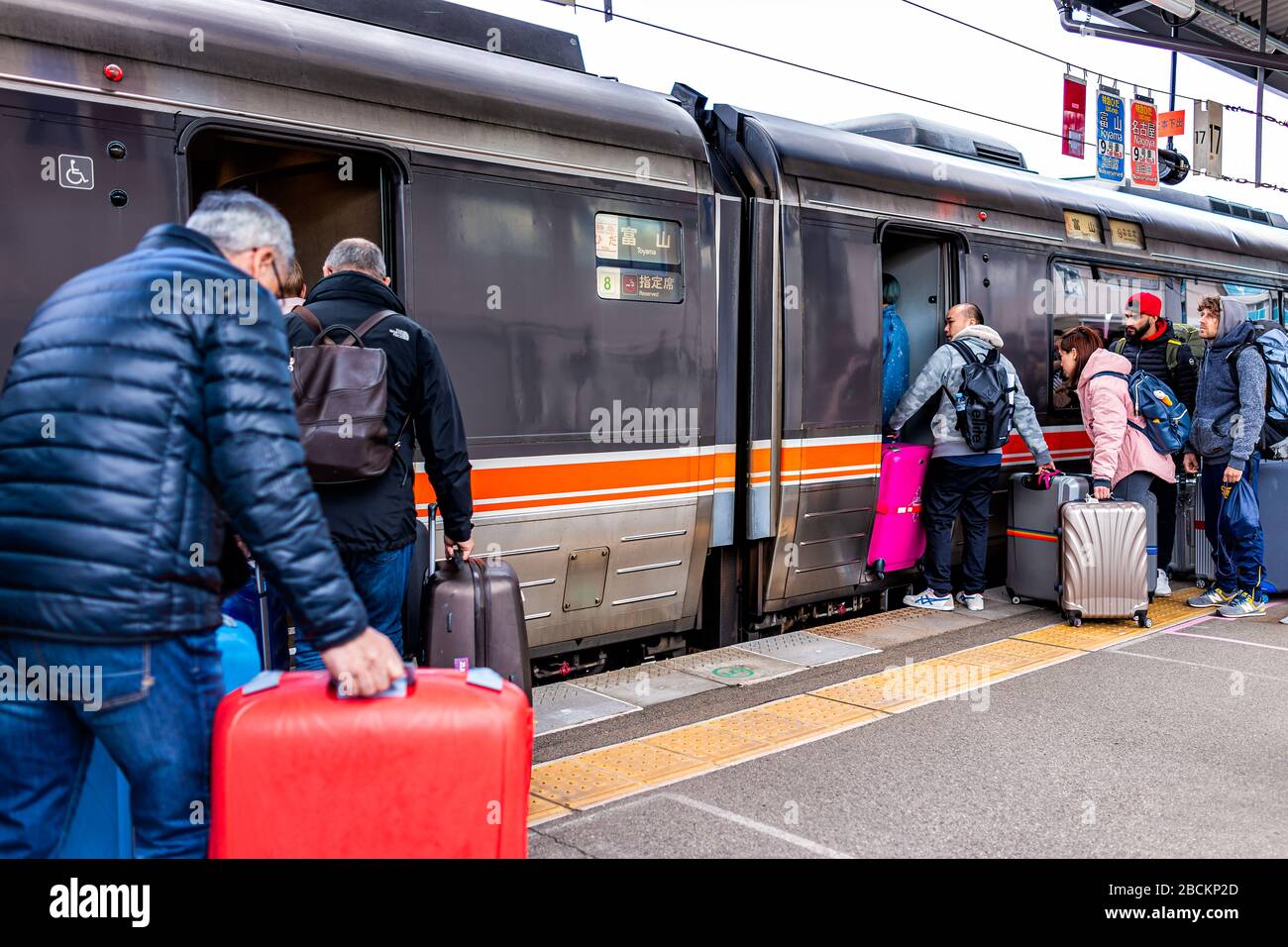 Takayama, Japan - April 8, 2019: JR train station platform with people boarding locomotive waiting in line queue in Gifu prefecture with Hida shinkans Stock Photo