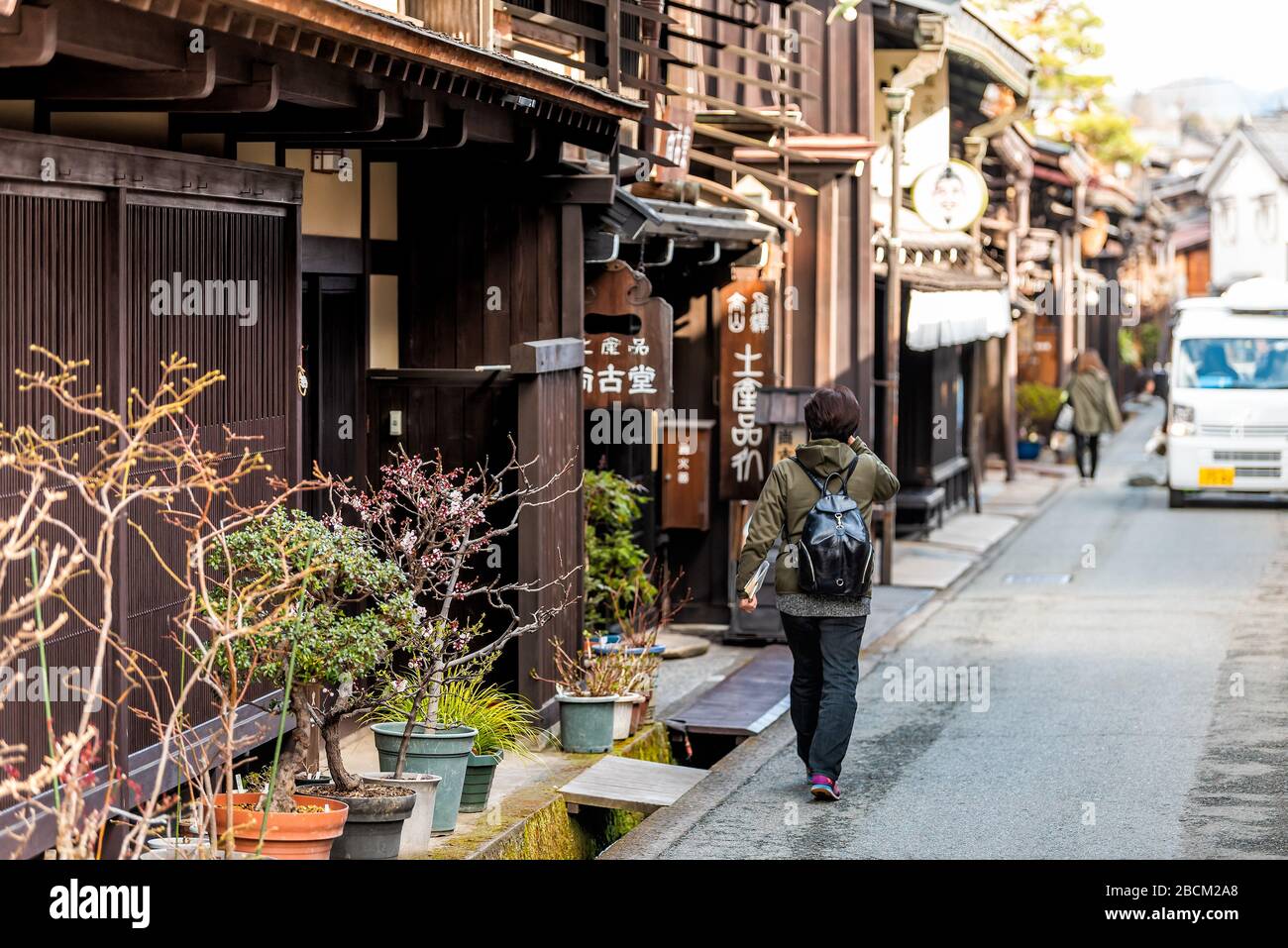 Takayama, Japan - April 9, 2019: Gifu prefecture in Japan with traditional wooden machiya residential houses architecture with people walking on narro Stock Photo