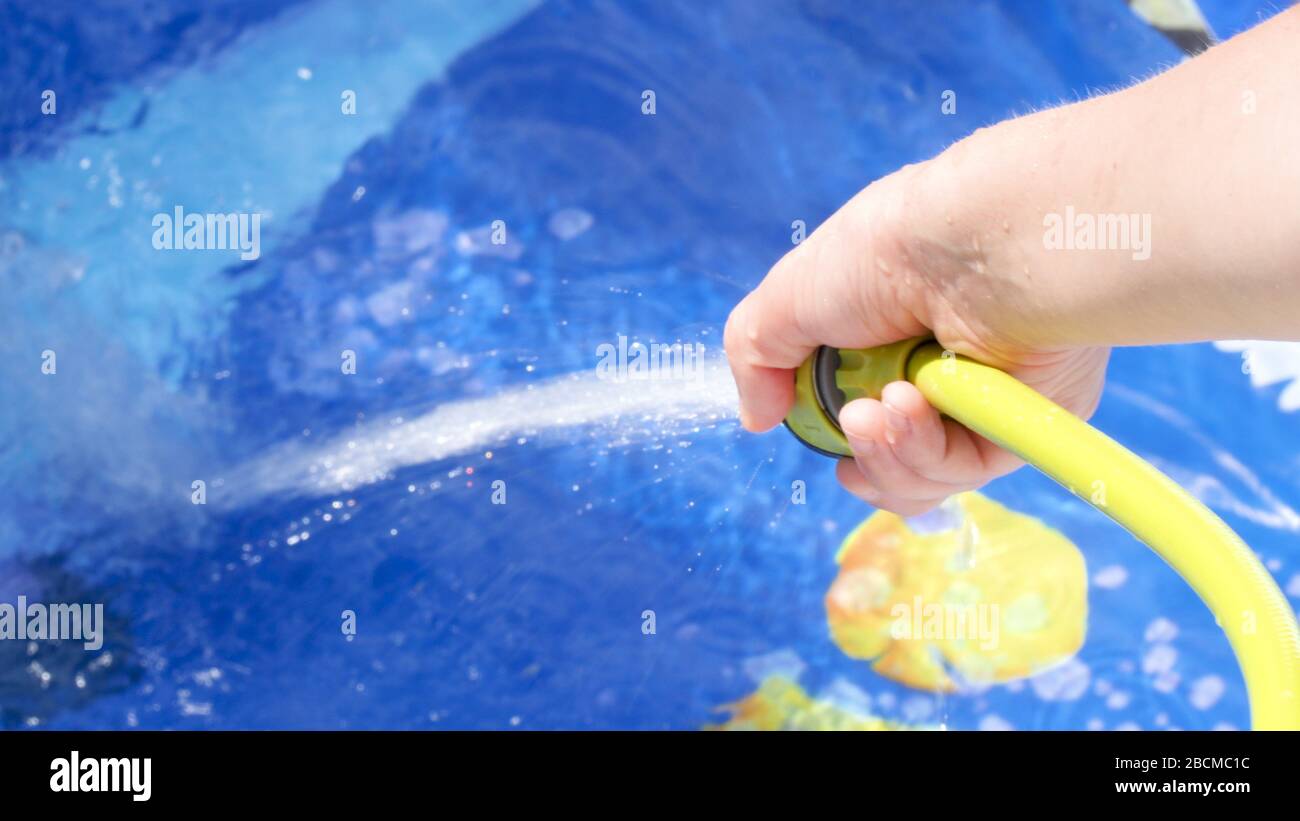 Filling Inflatable pool with water from hose in garden Stock Photo Alamy