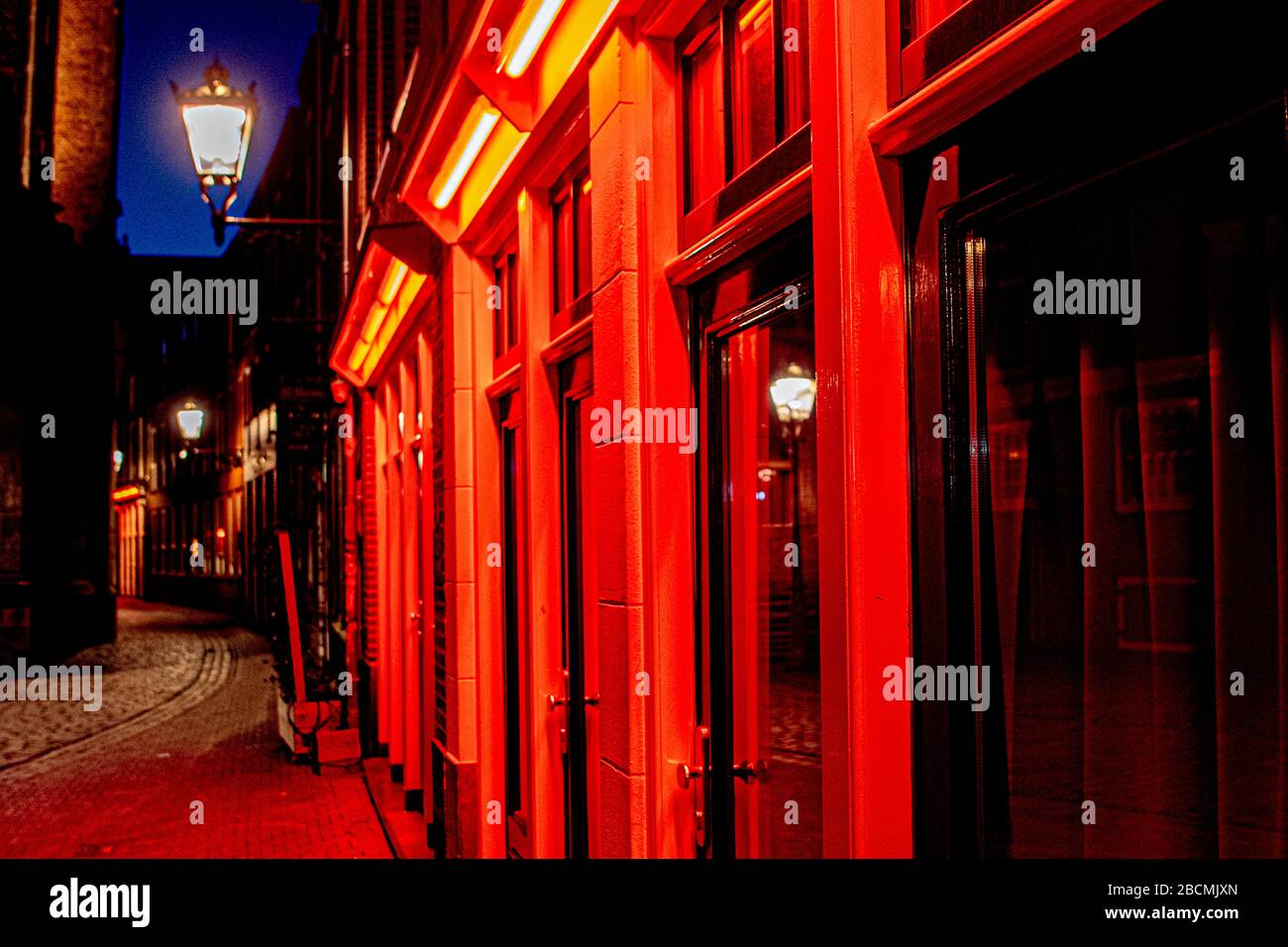 A view of an empty street at the world famous red light district due to the  coronavirus crisis. Normally more than 300 prostitutes offer their services  at the Amsterdamse wallen Stock Photo -