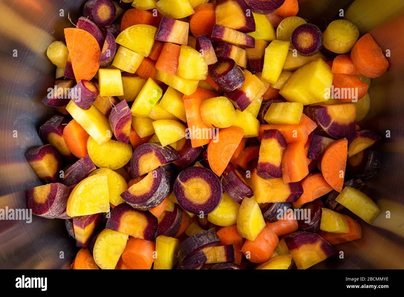 Diced rainbow carrots in a stainless-steel bowl, close-up Stock Photo