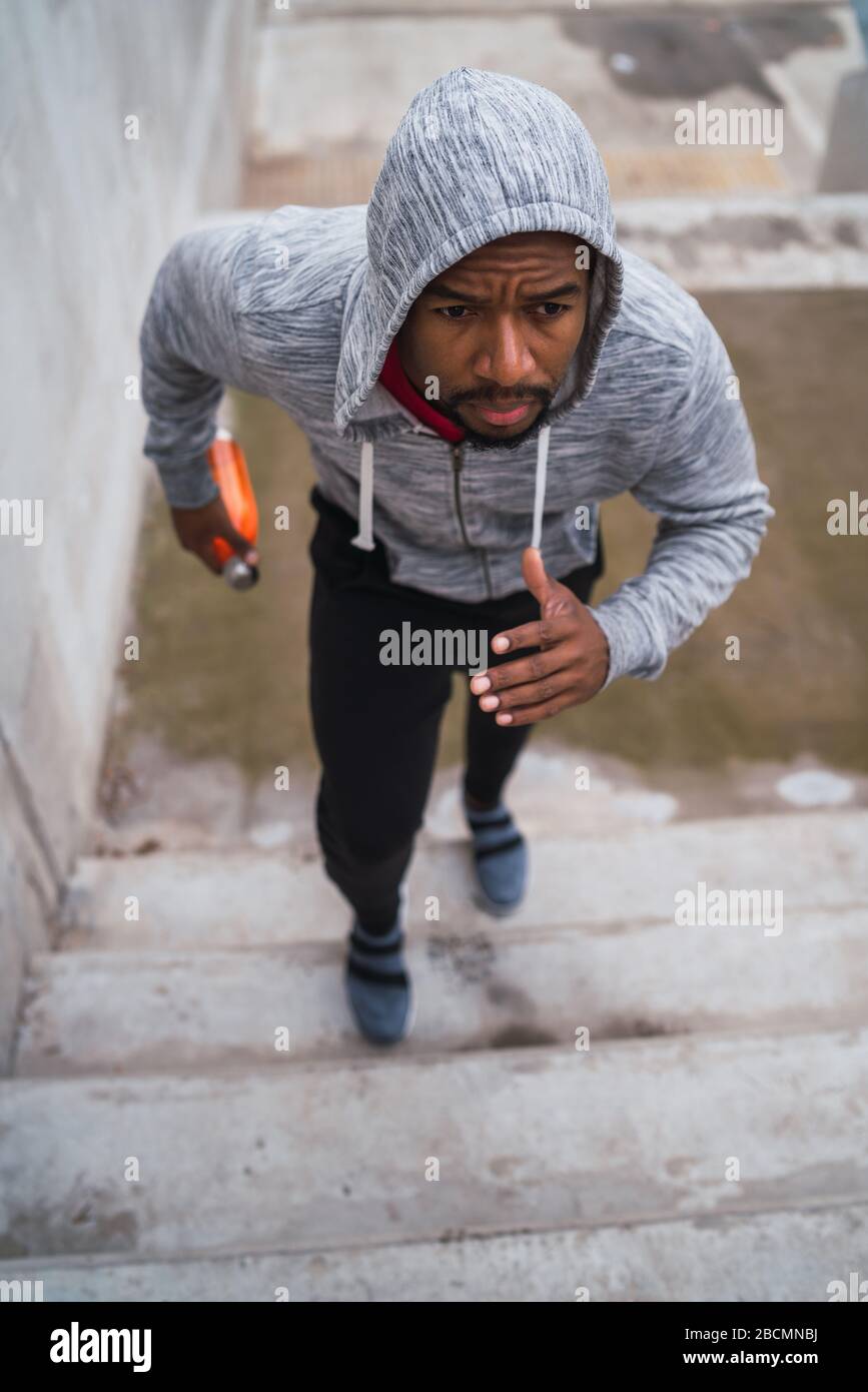 Portrait of a sport man running up on stairs outdoors. Fitness, sport and healthy lifestyle