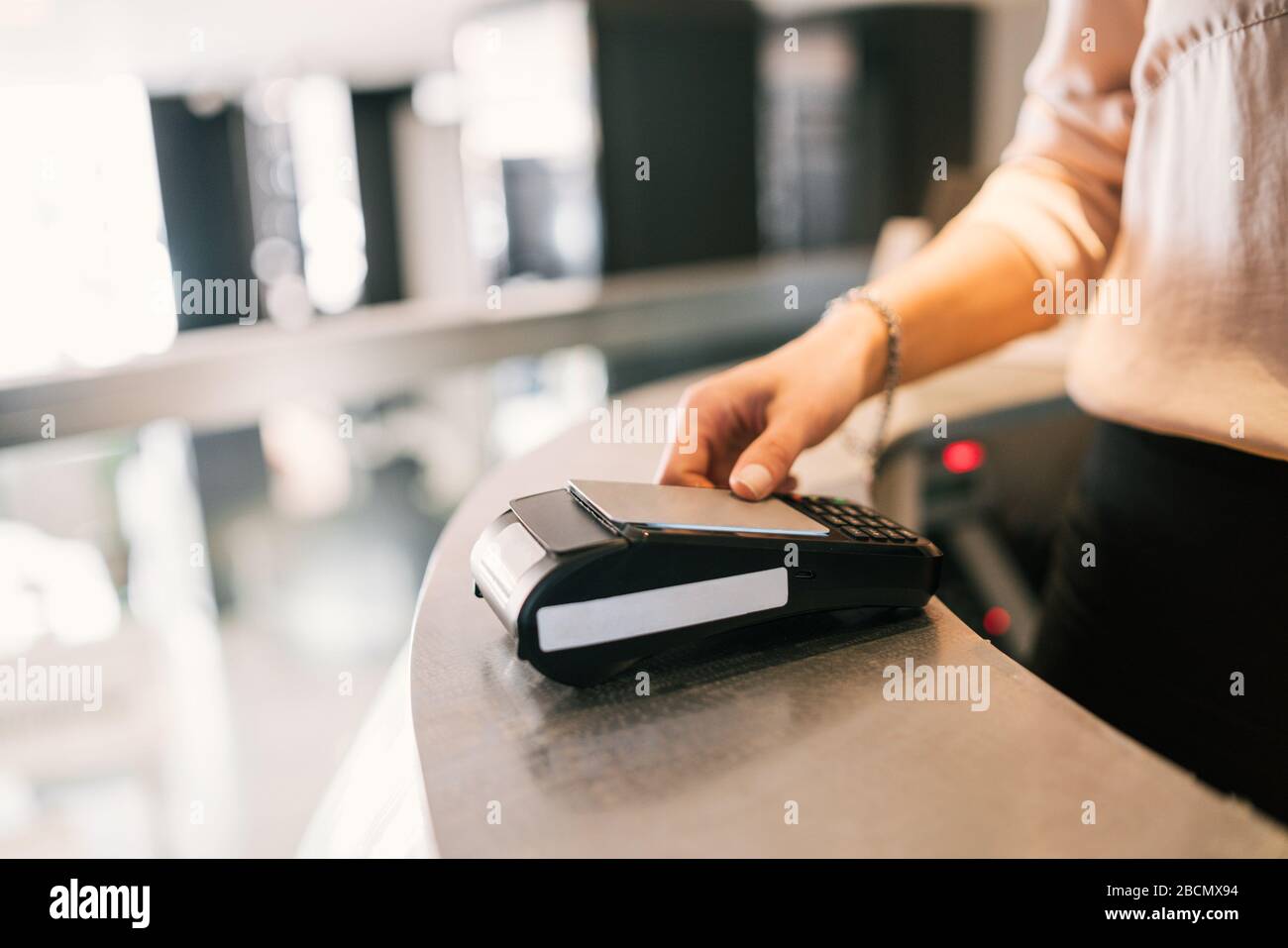 Close up of guest makes card payment at check-in at reception front desk. Travel concept. Stock Photo