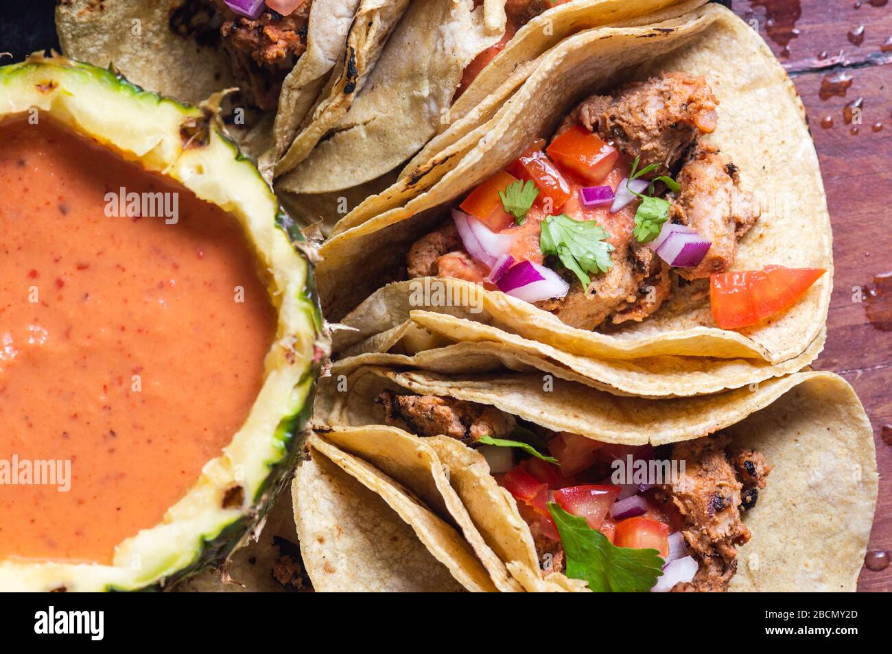 Tacos Al Pastor Shepherd's tacos, known as adobada tacos in the north of Mexico, spiced pork tacos with pineapple and spicy salsa Stock Photo