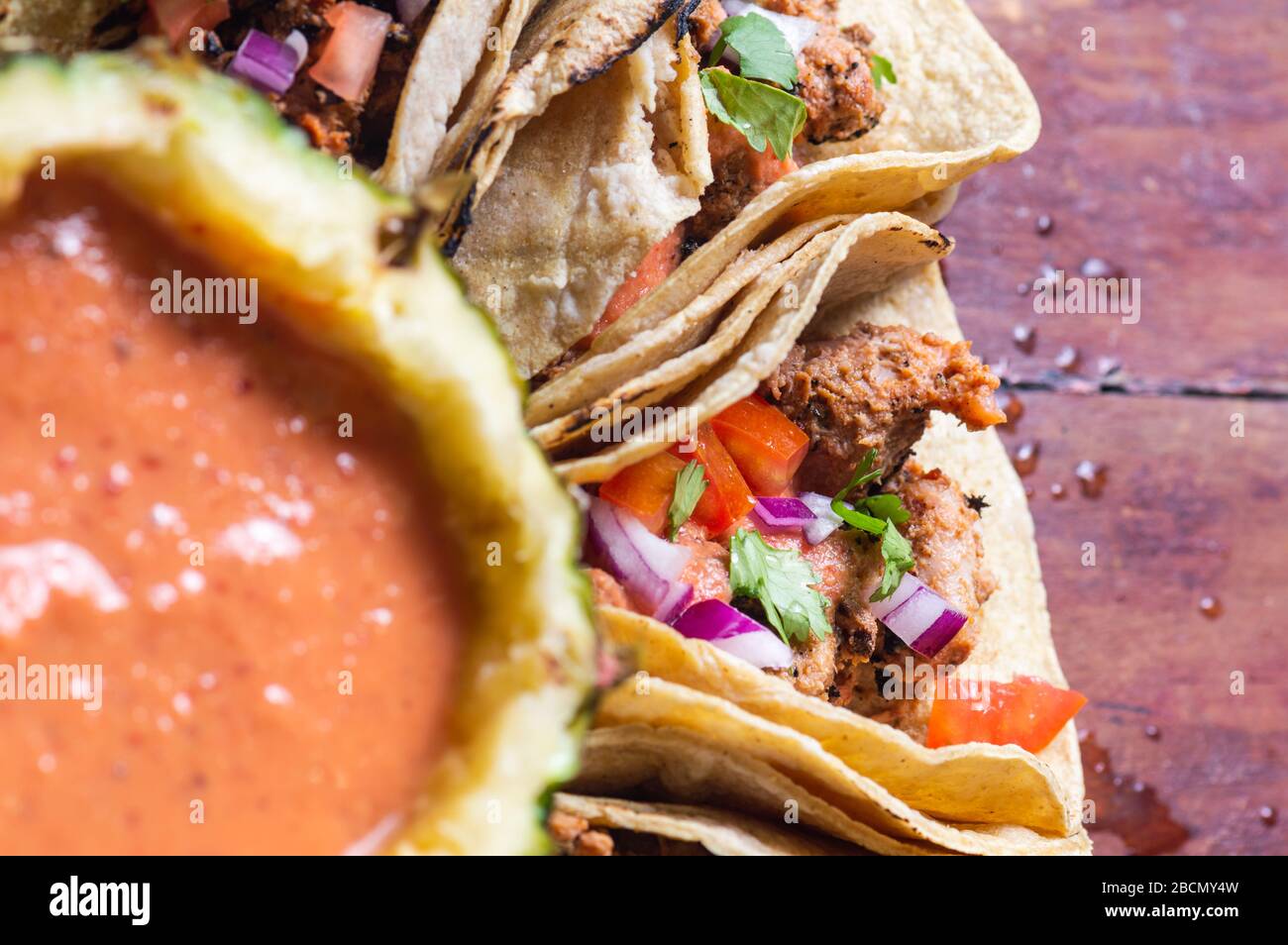 Tacos Al Pastor Shepherd's tacos, known as adobada tacos in the north of Mexico, spiced pork tacos with pineapple and spicy salsa Stock Photo