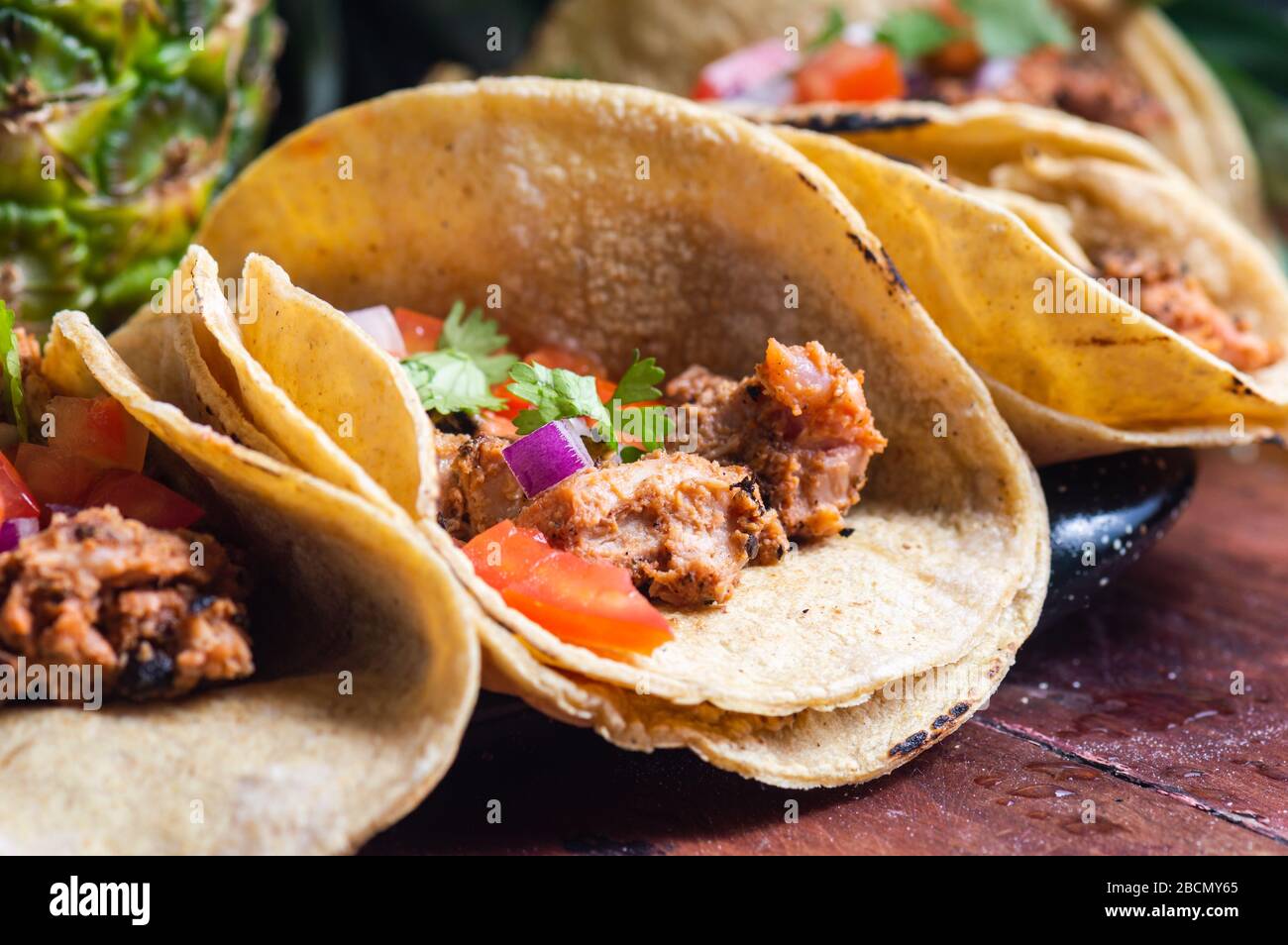 Tacos Al Pastor Shepherd's tacos, known as adobada tacos in the north of Mexico, spiced pork tacos with pineapple and spicy salsa Stock Photo