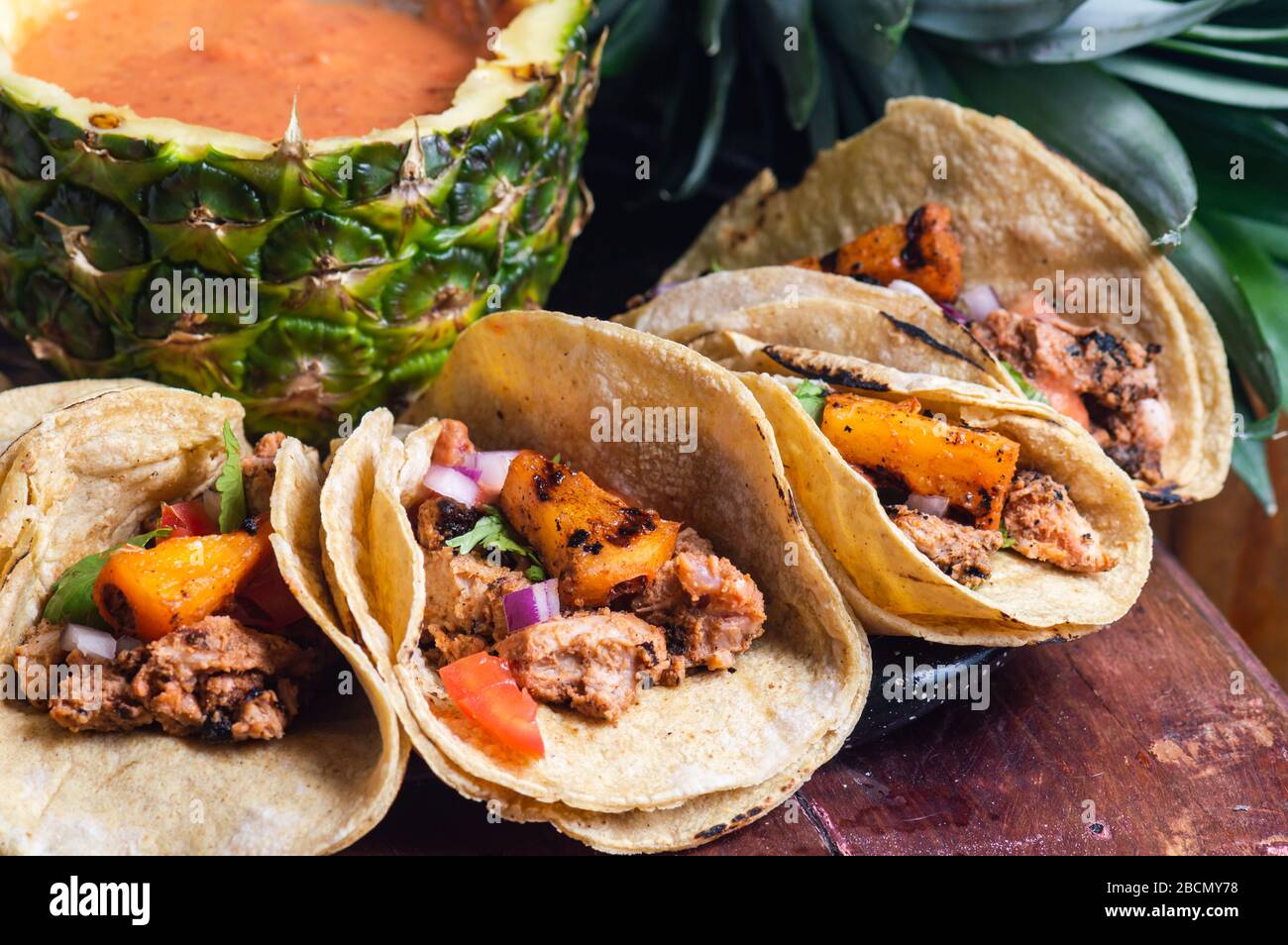 Tacos Al Pastor Shepherd's tacos, known as adobada tacos in the north of Mexico, spiced pork tacos with pineapple and spicy salsa Stock Photo