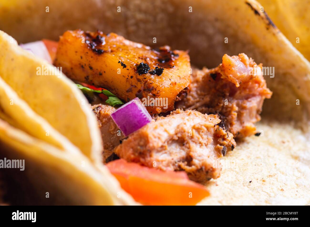 Tacos Al Pastor Shepherd's tacos, known as adobada tacos in the north of Mexico, spiced pork tacos with pineapple and spicy salsa Stock Photo