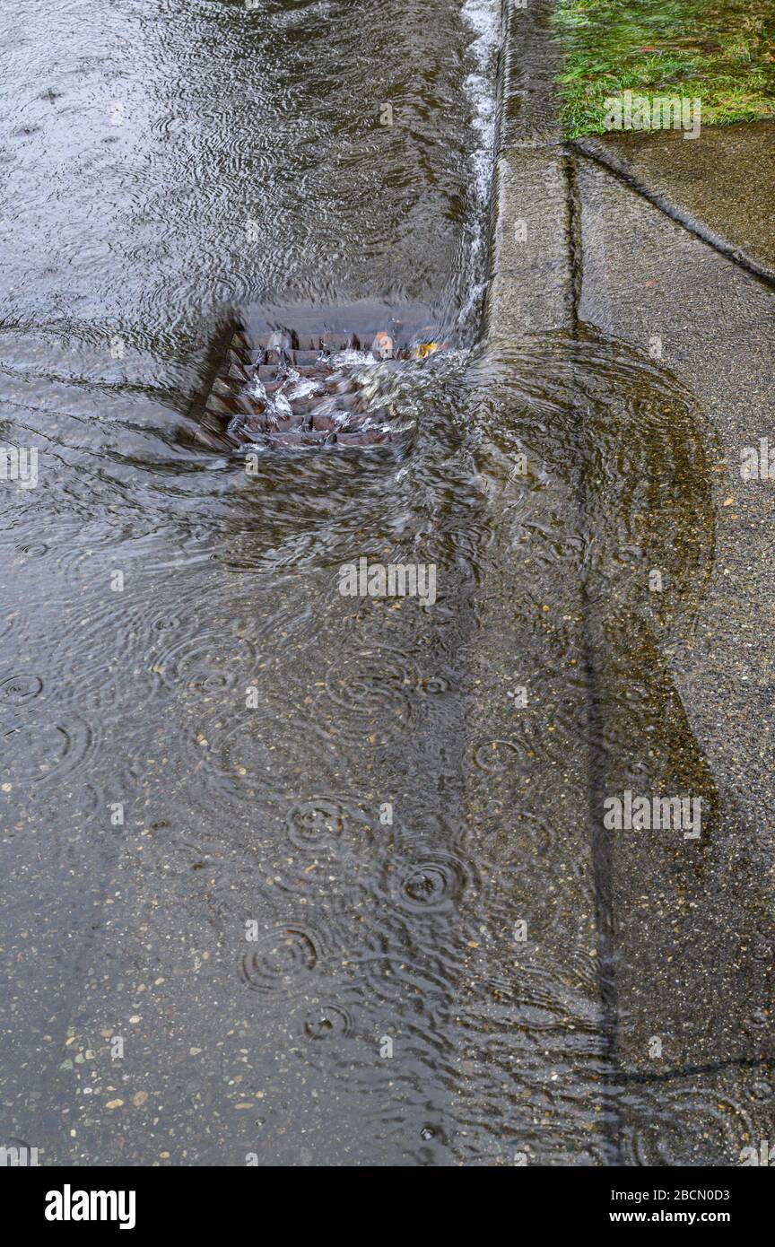 Heavy rain caused flooding in street, water swirling around storm drain ...