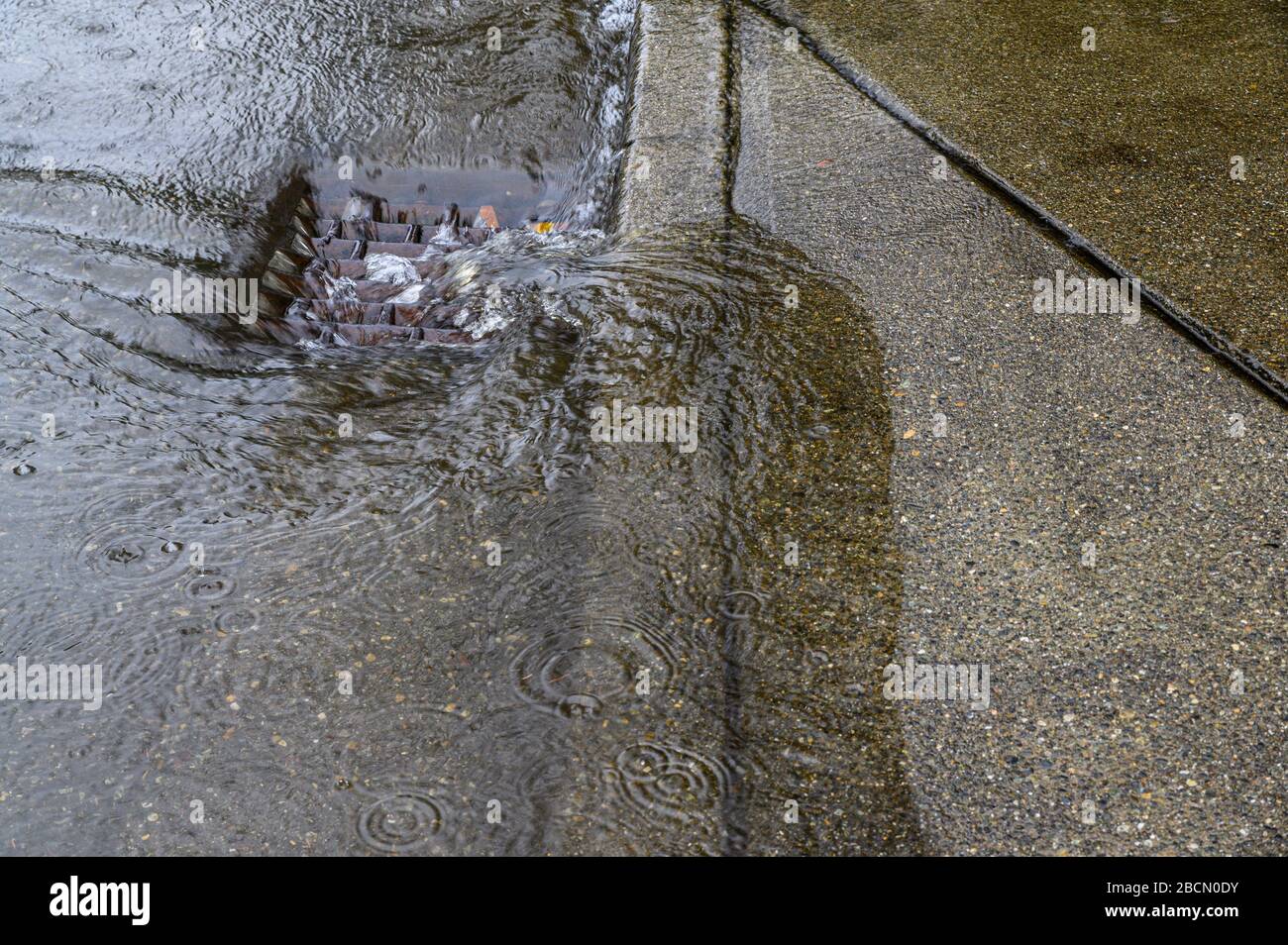 Heavy rain caused flooding in street, water swirling around storm drain ...