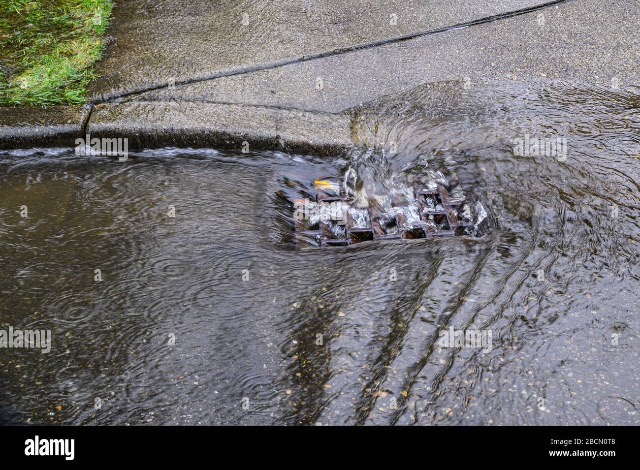 Heavy rain caused flooding in street, water swirling around storm drain ...