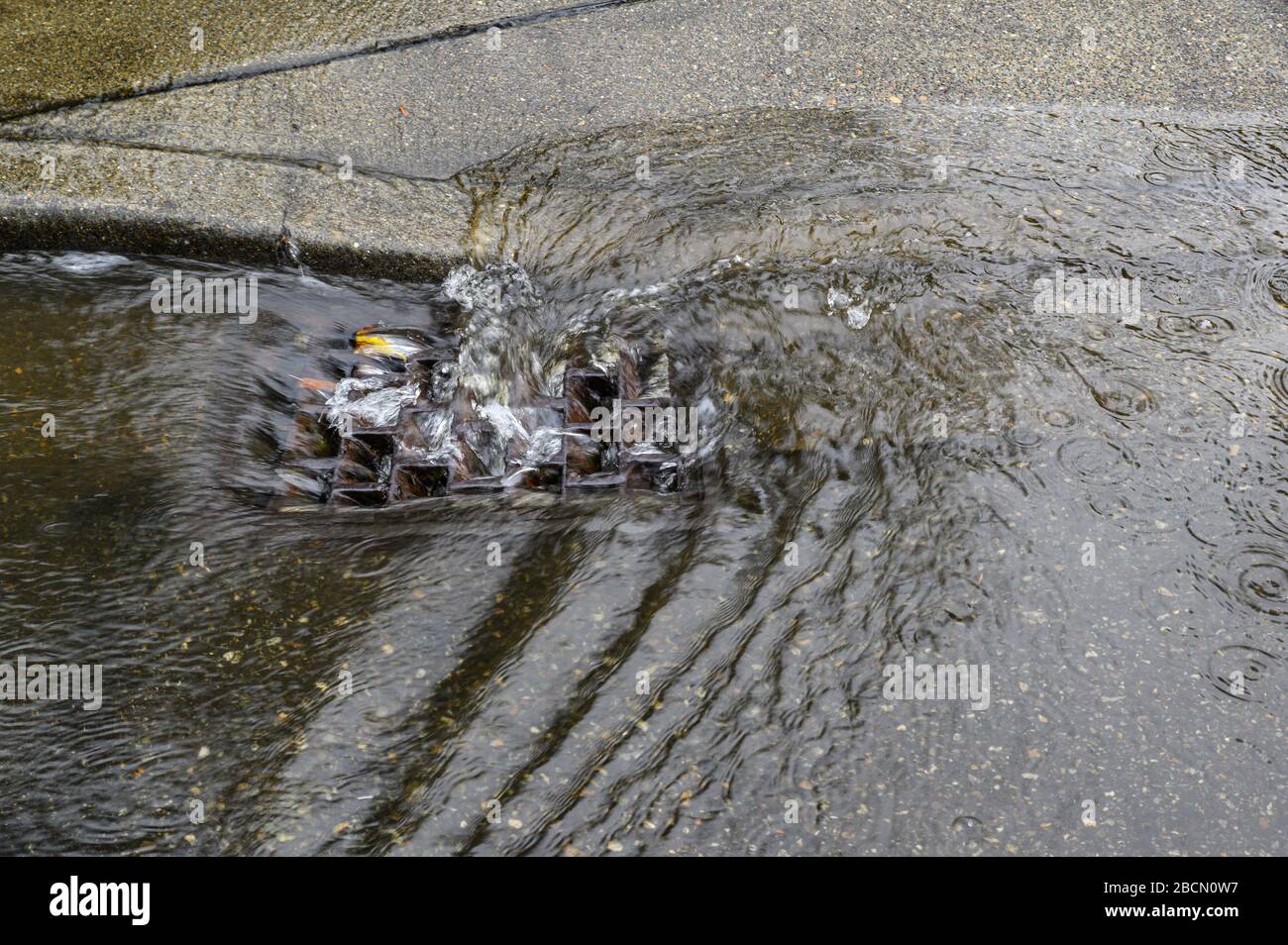 Heavy rain caused flooding in street, water swirling around storm drain ...