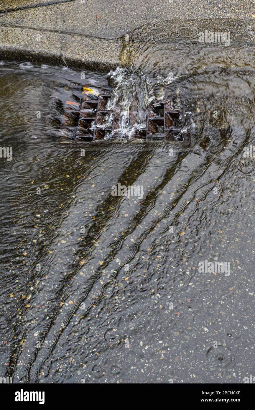 Heavy rain caused flooding in street, water swirling around storm drain ...