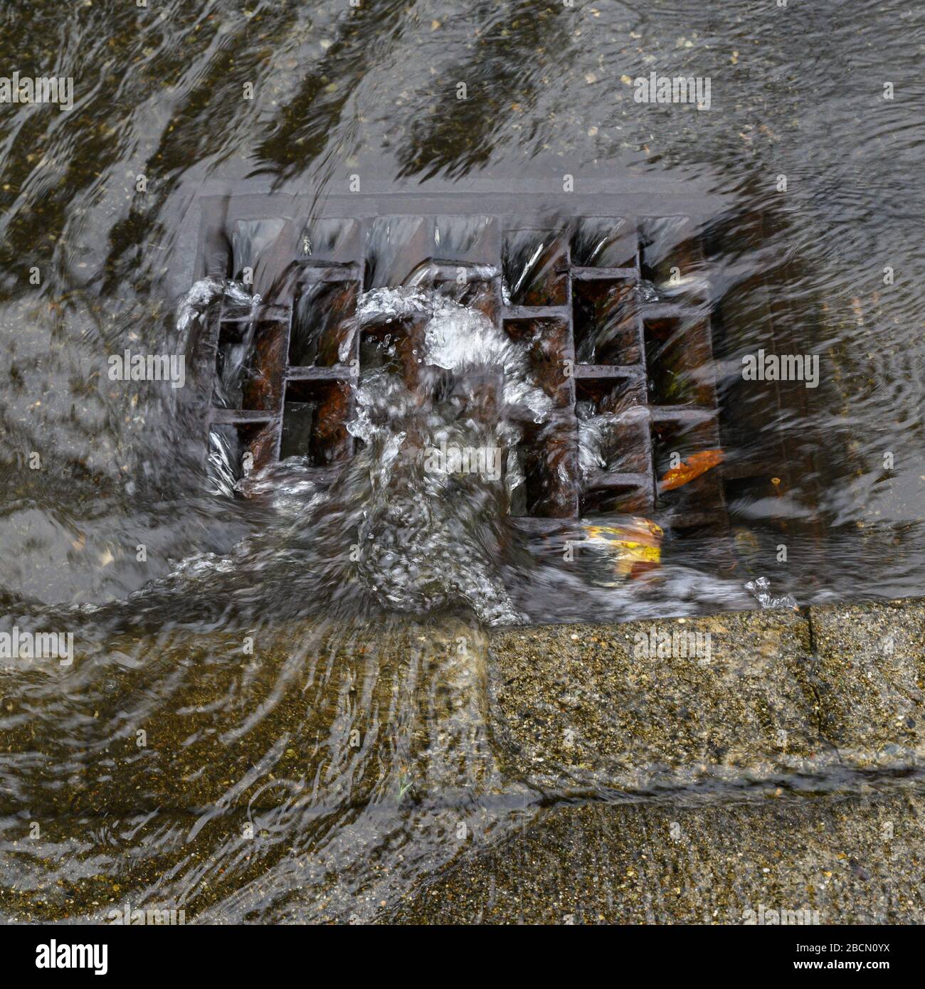 Heavy rain caused flooding in street, water swirling around storm drain ...