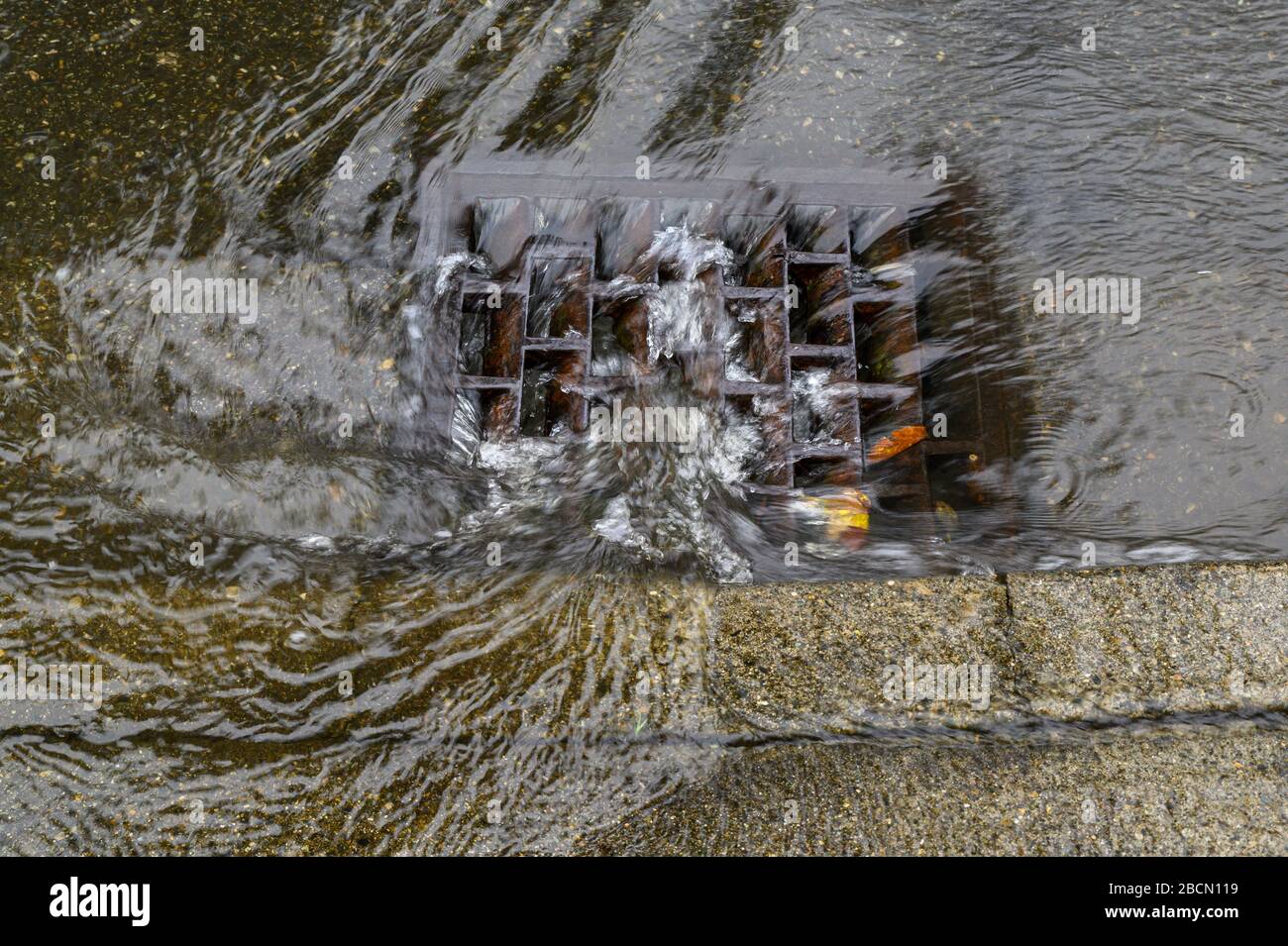 Heavy rain caused flooding in street, water swirling around storm drain ...