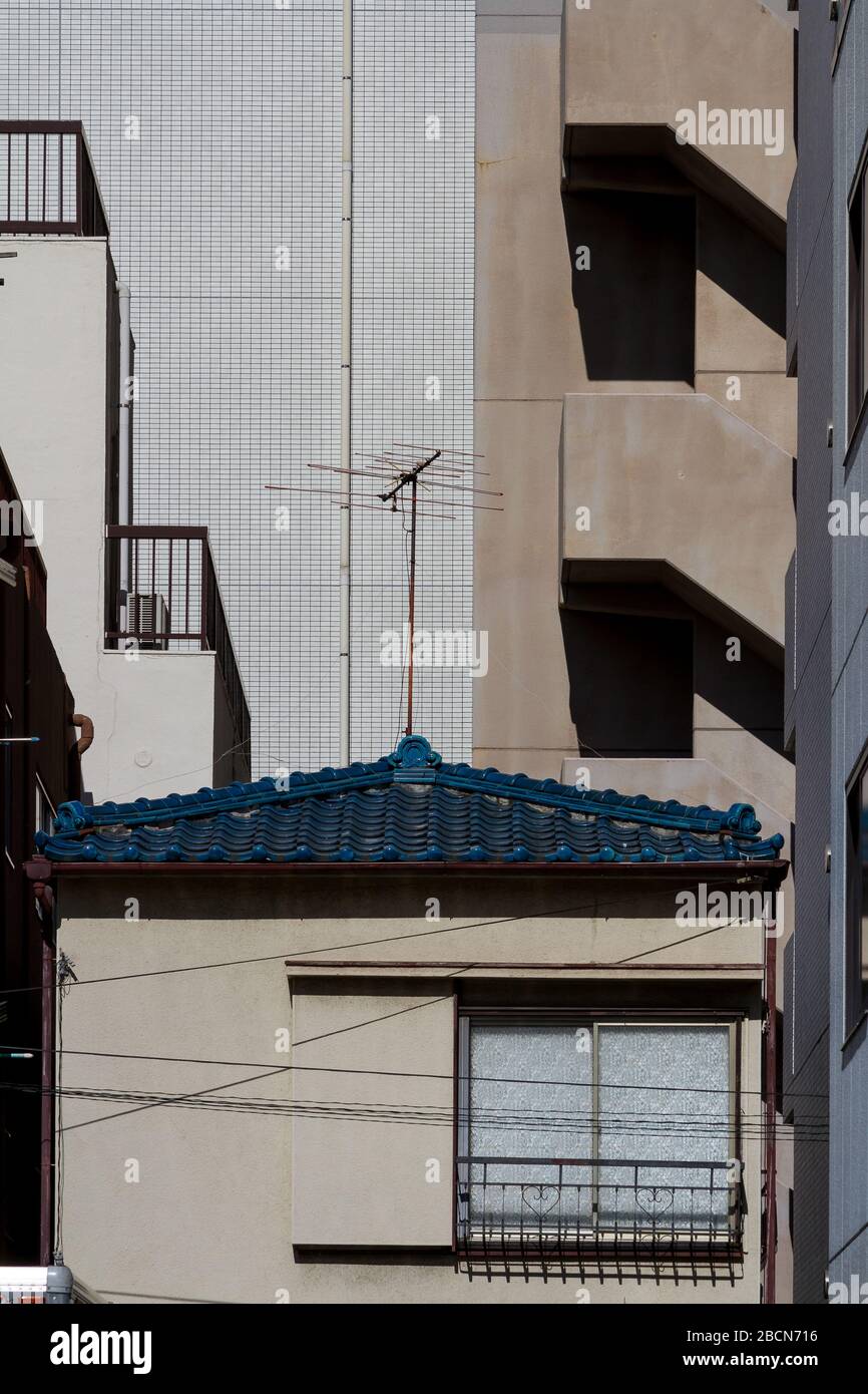 A small house in between taller building in Tokyo, Japan. Stock Photo