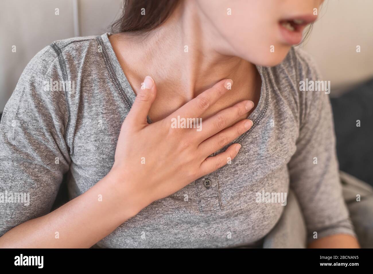 COVID-19 shortness of breath pneumonia woman with Corona virus symptoms such as, fever, body aches breathing difficulties. Stock Photo