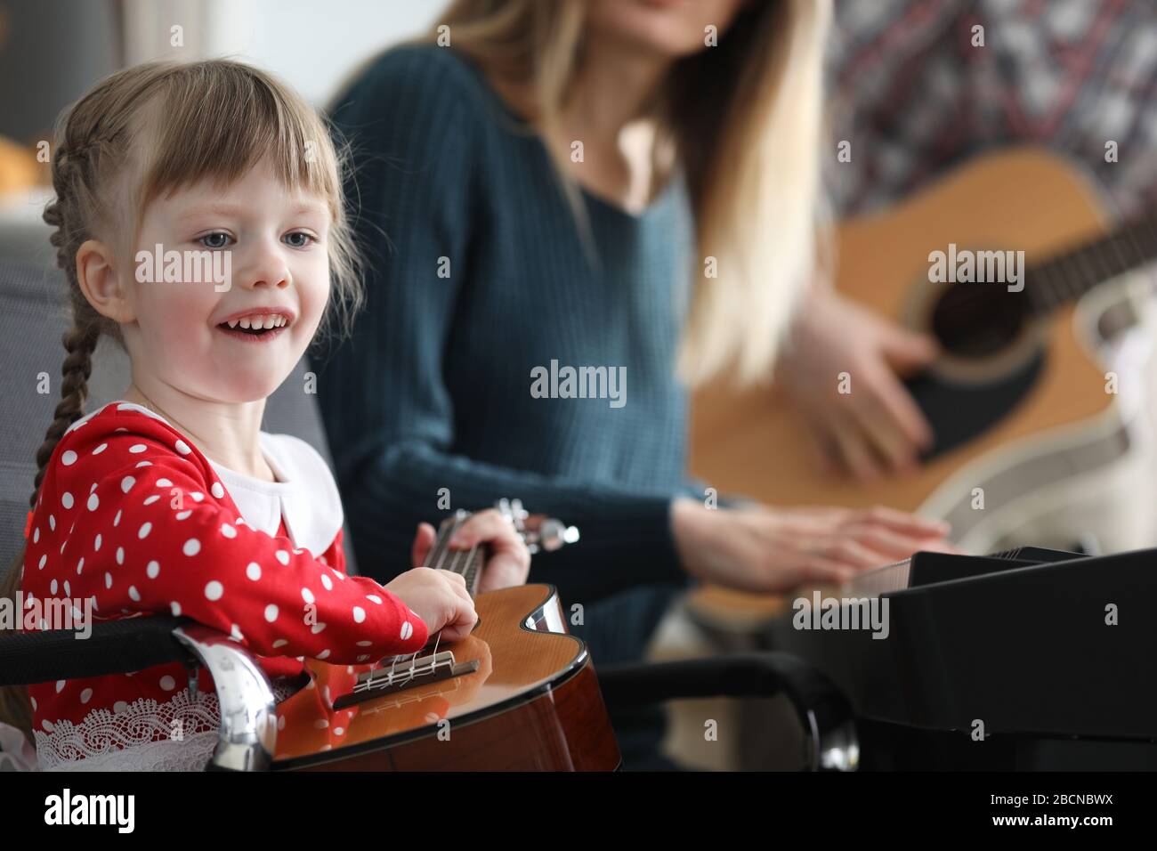 Baby learns play musical instruments with parents Stock Photo Alamy