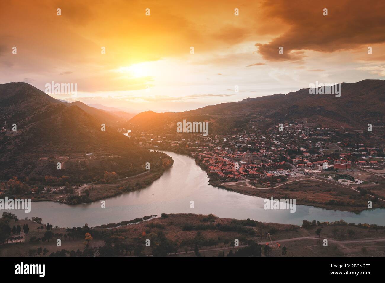 Golden sunset over the valley with rivers and mountains. Panoramic evening view of Mtskheta city and Kura with Aragvi rivers from Jvari Monastery. Geo Stock Photo