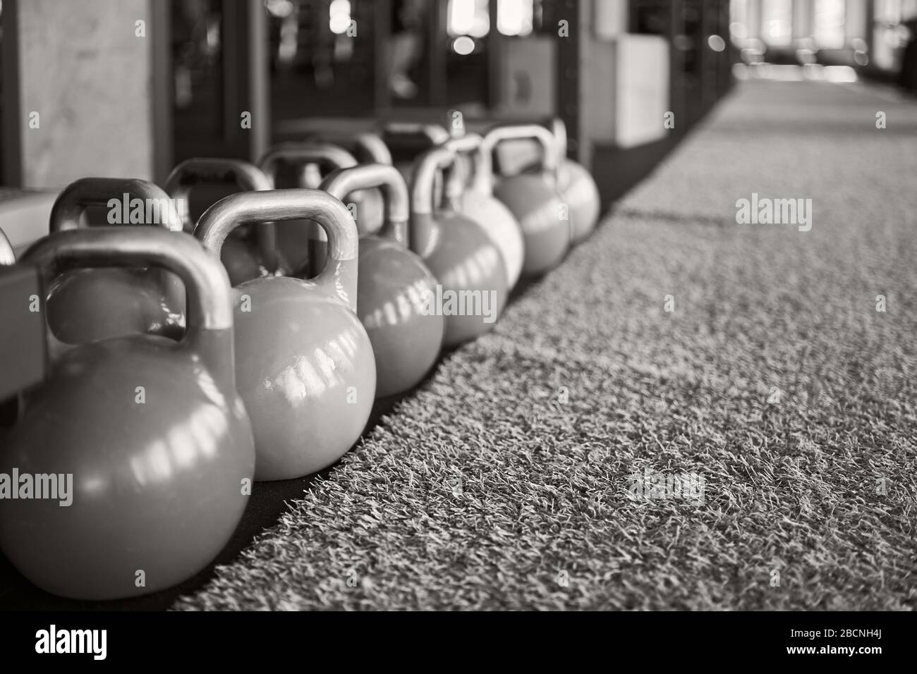 Close up of kettle bells on floor near fake grass, black and white.  Selective focus of heavy steel equipment in gym, daylight. Concept of  sport, weigh Stock Photo - Alamy