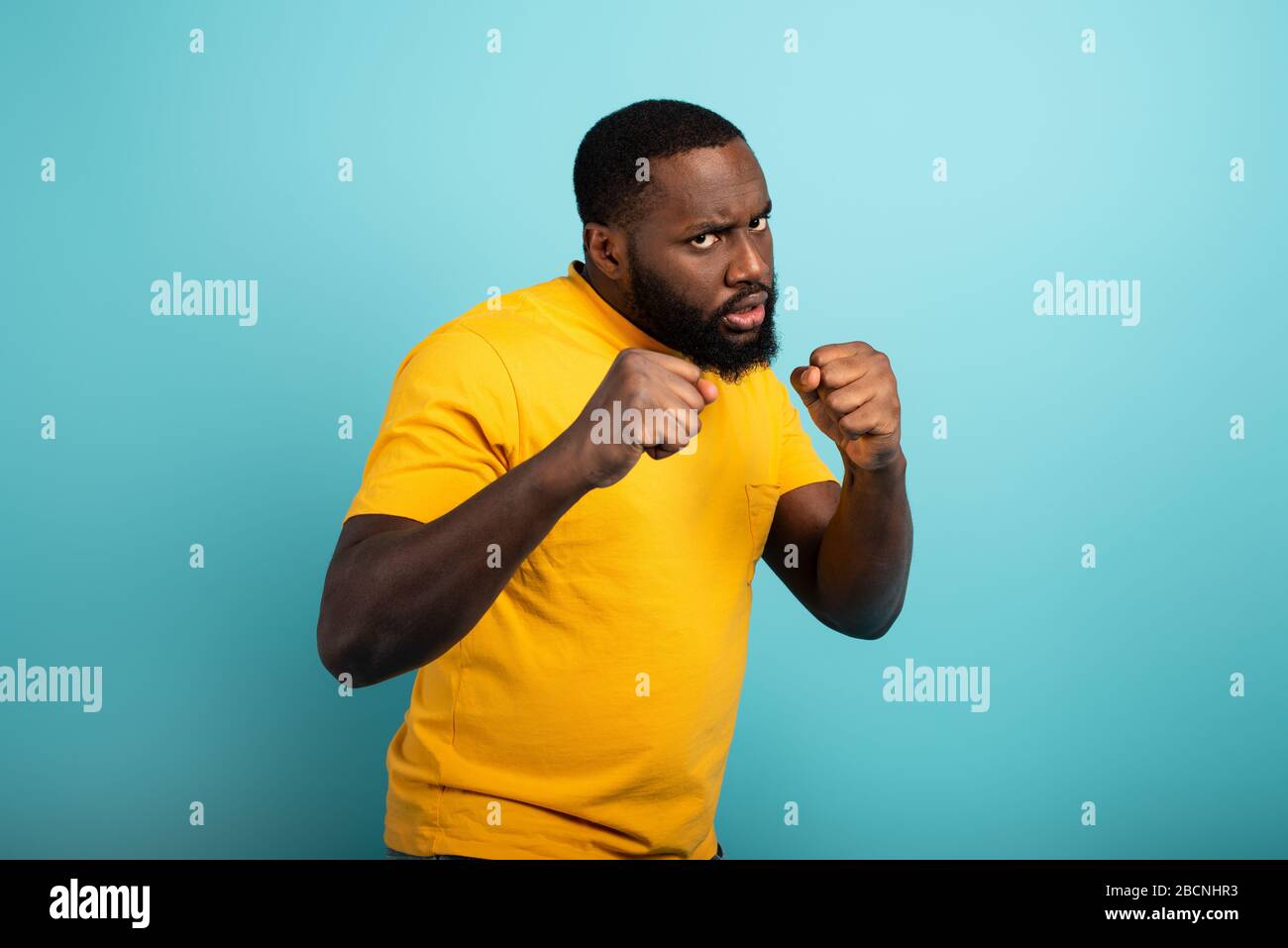 Man attacks with a punch the covid19 coronavirus. Blue background Stock Photo