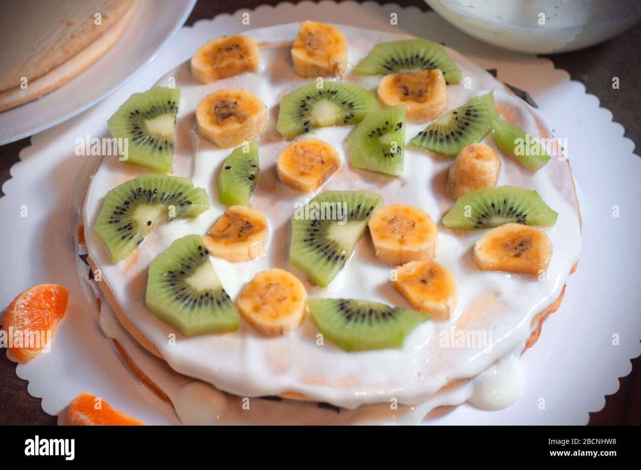 Homemade cake with honey, decorate with exotic fruit: kiwi and banana. Homemade cake with fruit Stock Photo