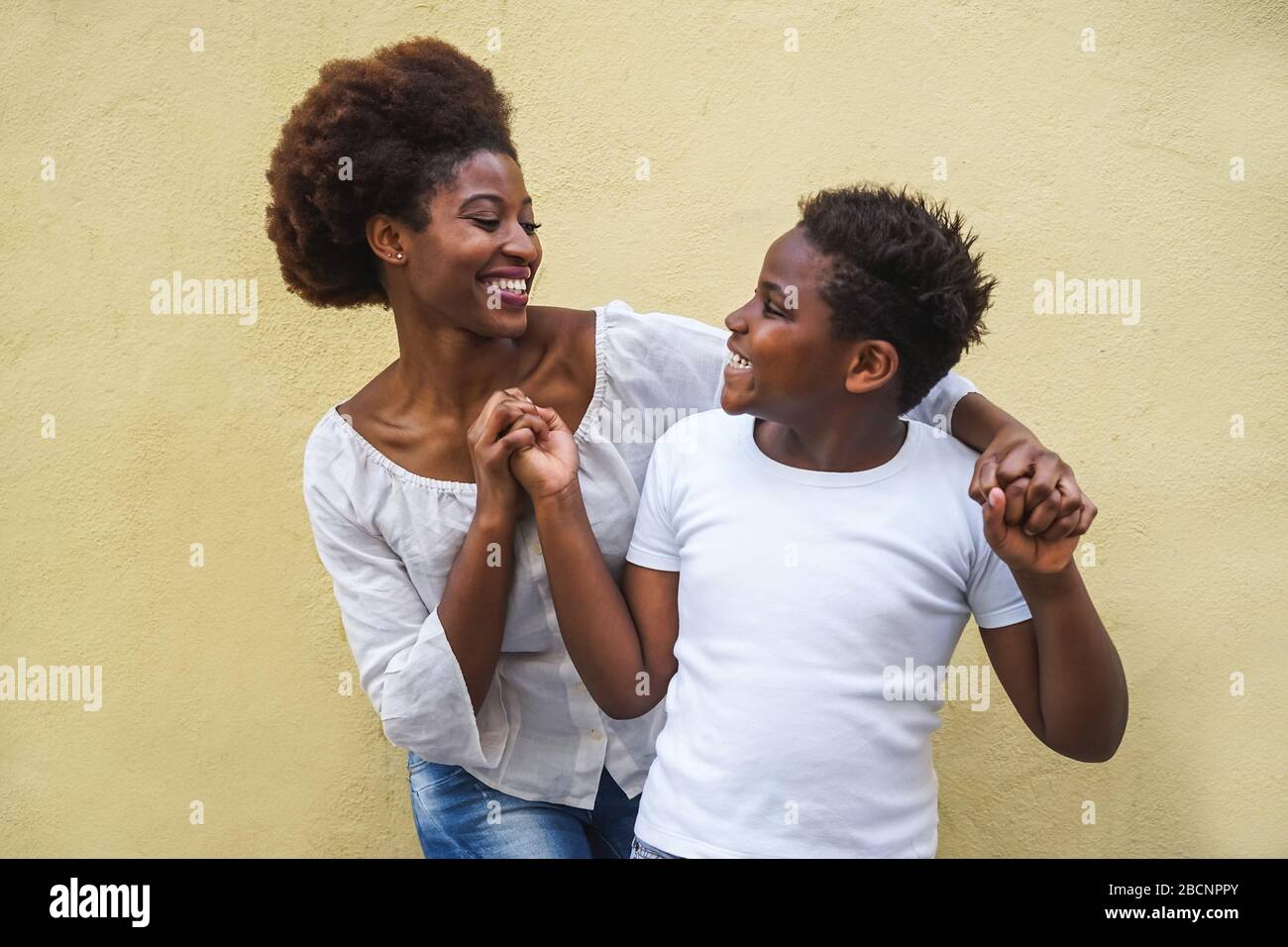 Happy young mother having fun with her child Mom playing and dancing