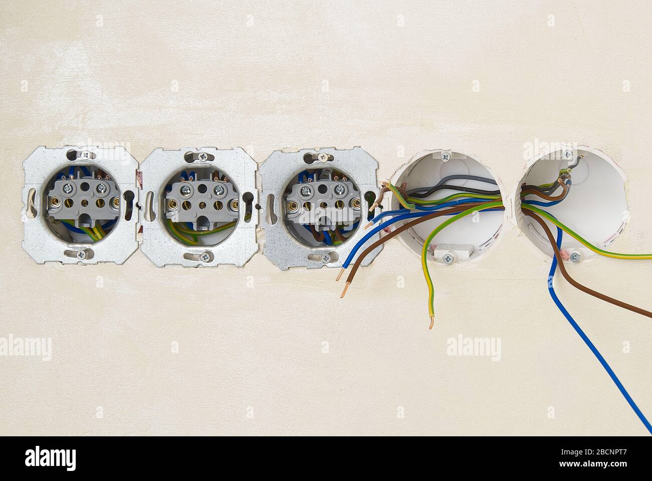 Electrician install outlets on beige wall with eu standards Stock Photo