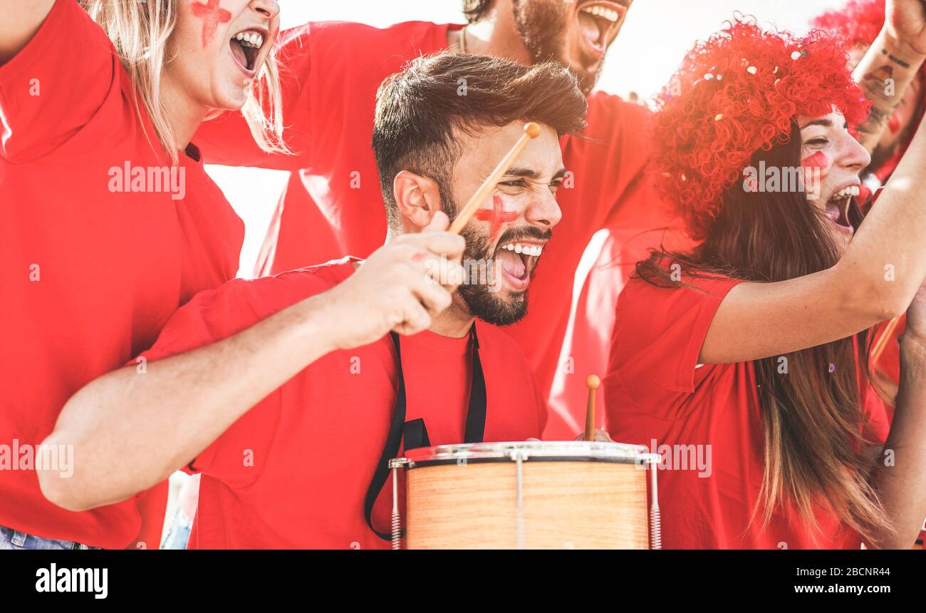 Red sport fans screaming while supporting their team out of the stadium