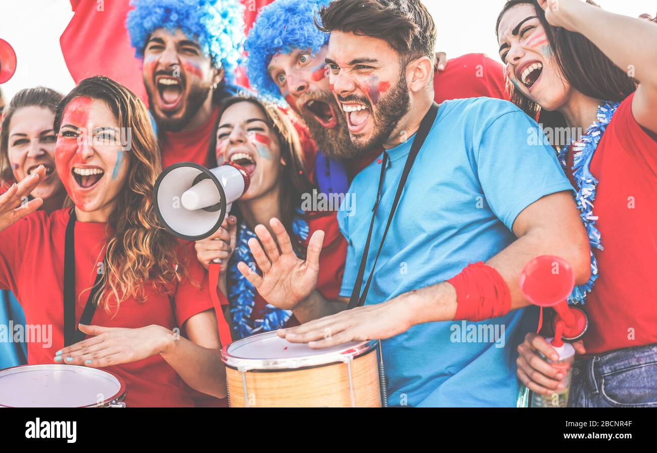 Crazy sport fans playing drums and screaming while supporting their
