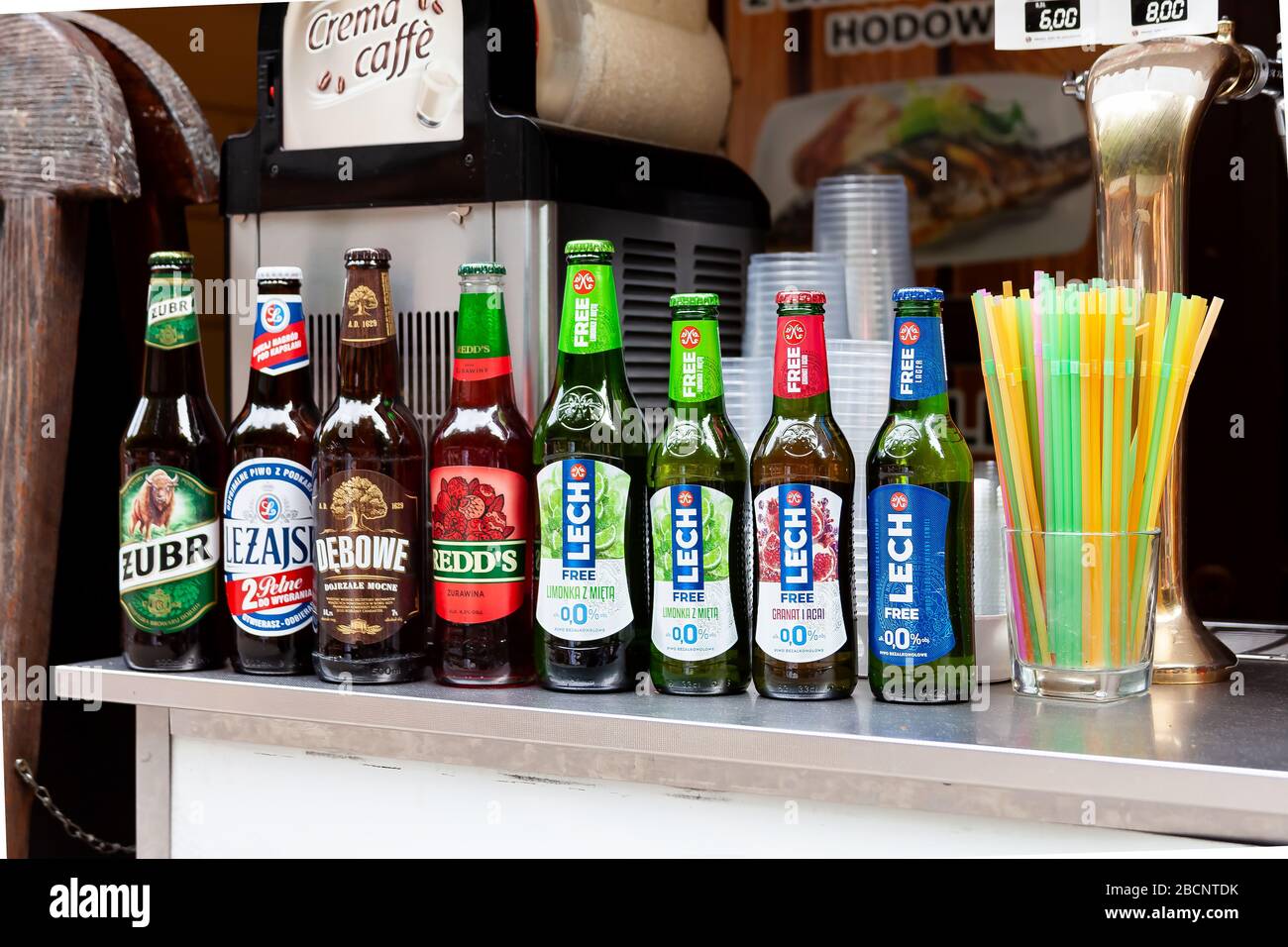 Set of Polish beer bottles in a row, various brands, many alcohol bottles and plastic straws in container Żubr, Leżajsk, Dębowe, Lech, Redd's and 0% Stock Photo