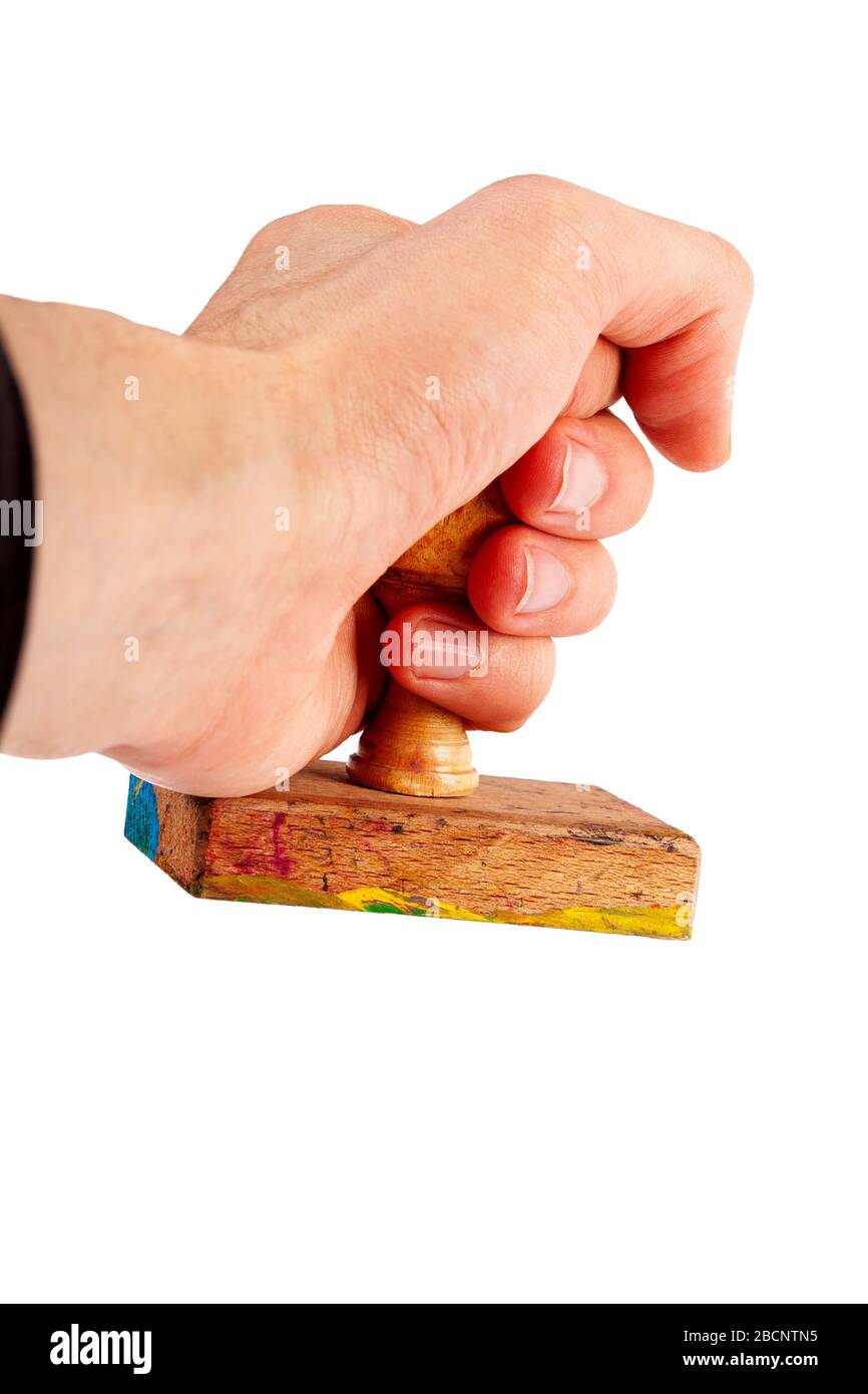Wooden rubber stamp in hand, holding a simple traditional handstamp