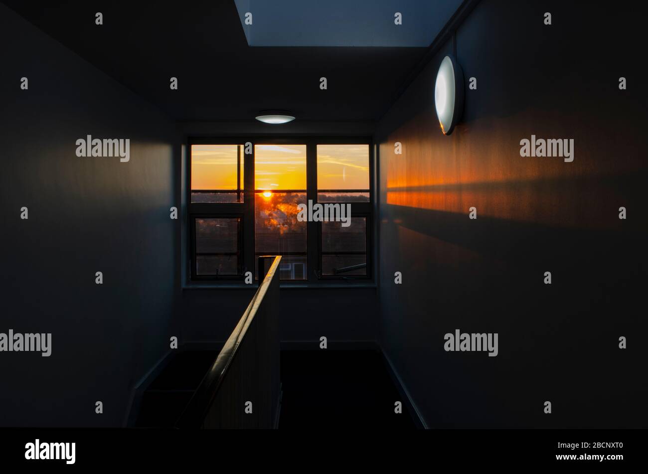 Sunset in a stairwell of a tower block of London flats. Through the