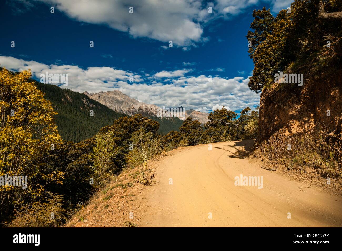 Dirt road on the road with no name between Batang and Ganbai Road, Sichuan Province shadowing the Tibetan border Stock Photo