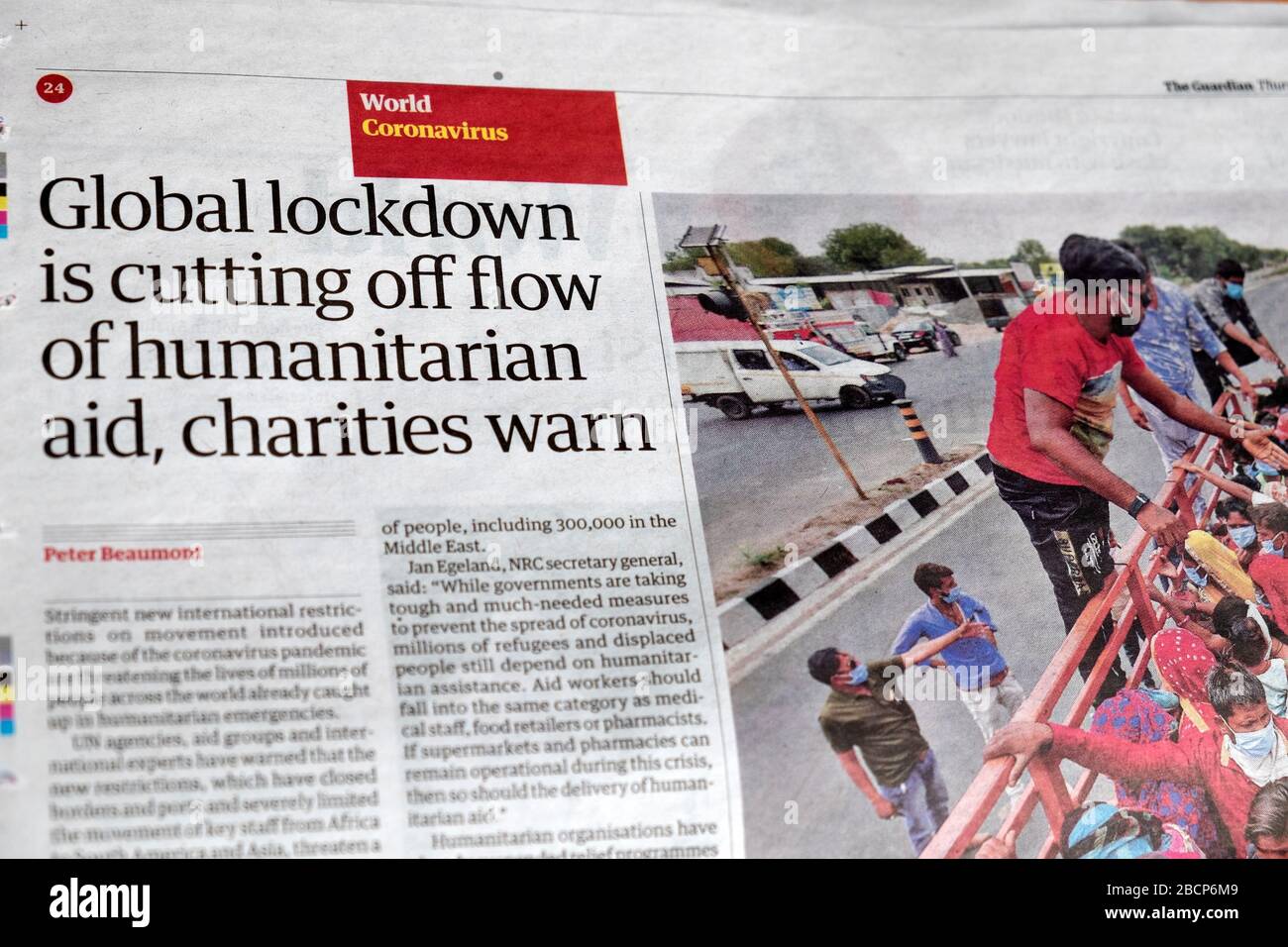 'Global lockdown is cutting off flow of humanitarian aid, charities warn'  Coronavirus article inside page Guardian newspaper March 2020 London UK Stock Photo
