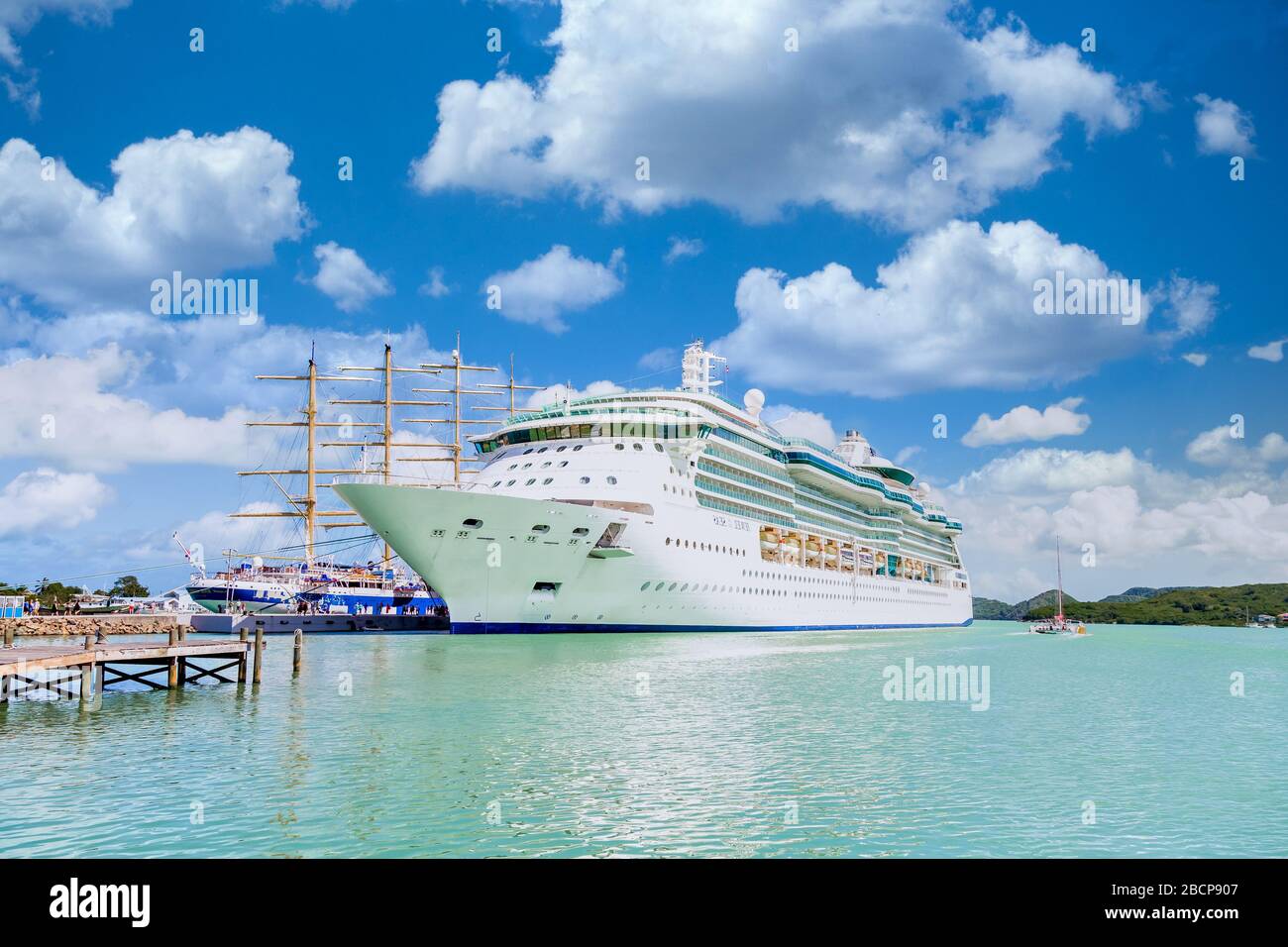White Cruise Ship by Wood Masts Stock Photo