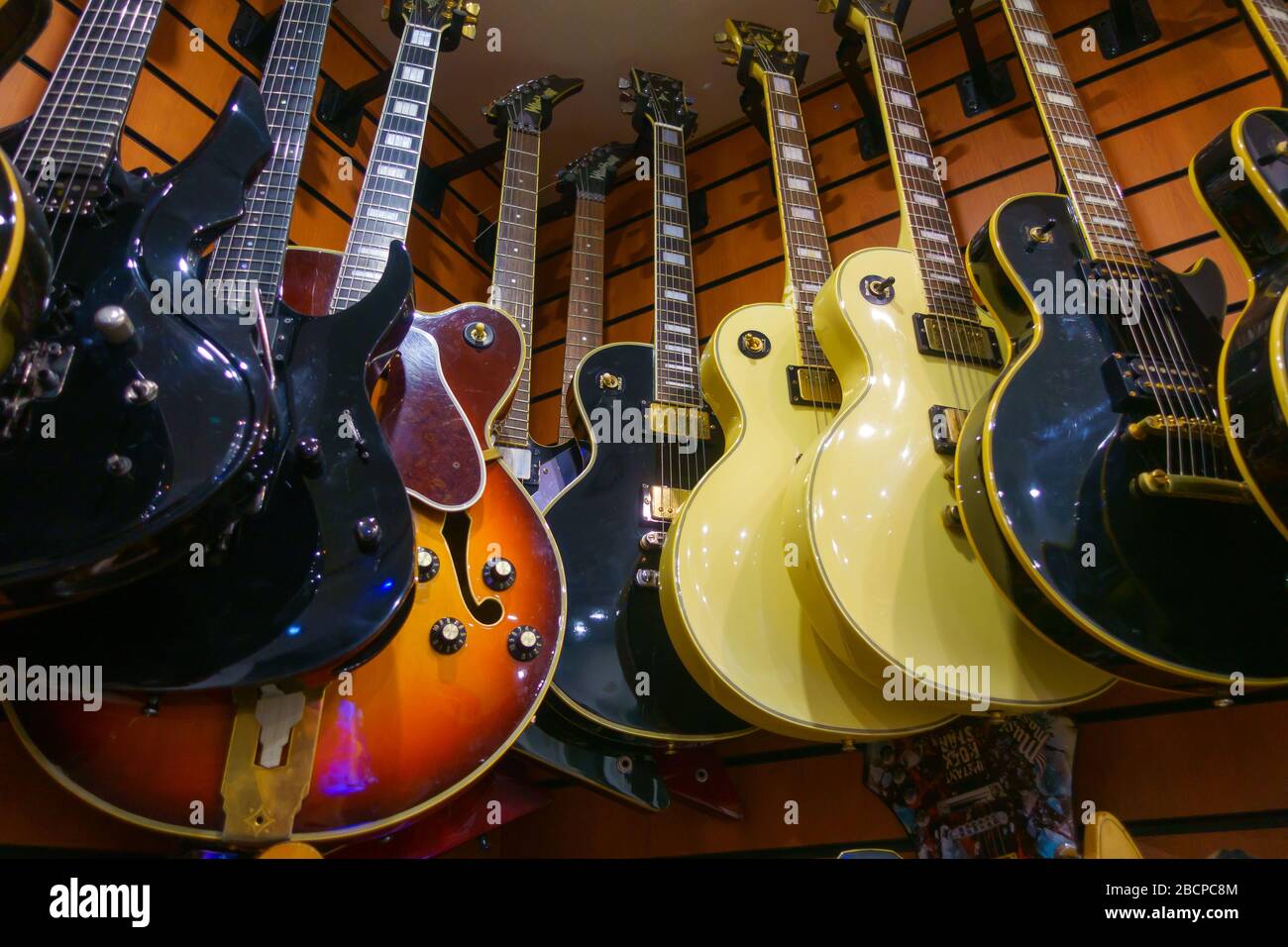 Different electric guitars hang in the music instruments store Stock ...