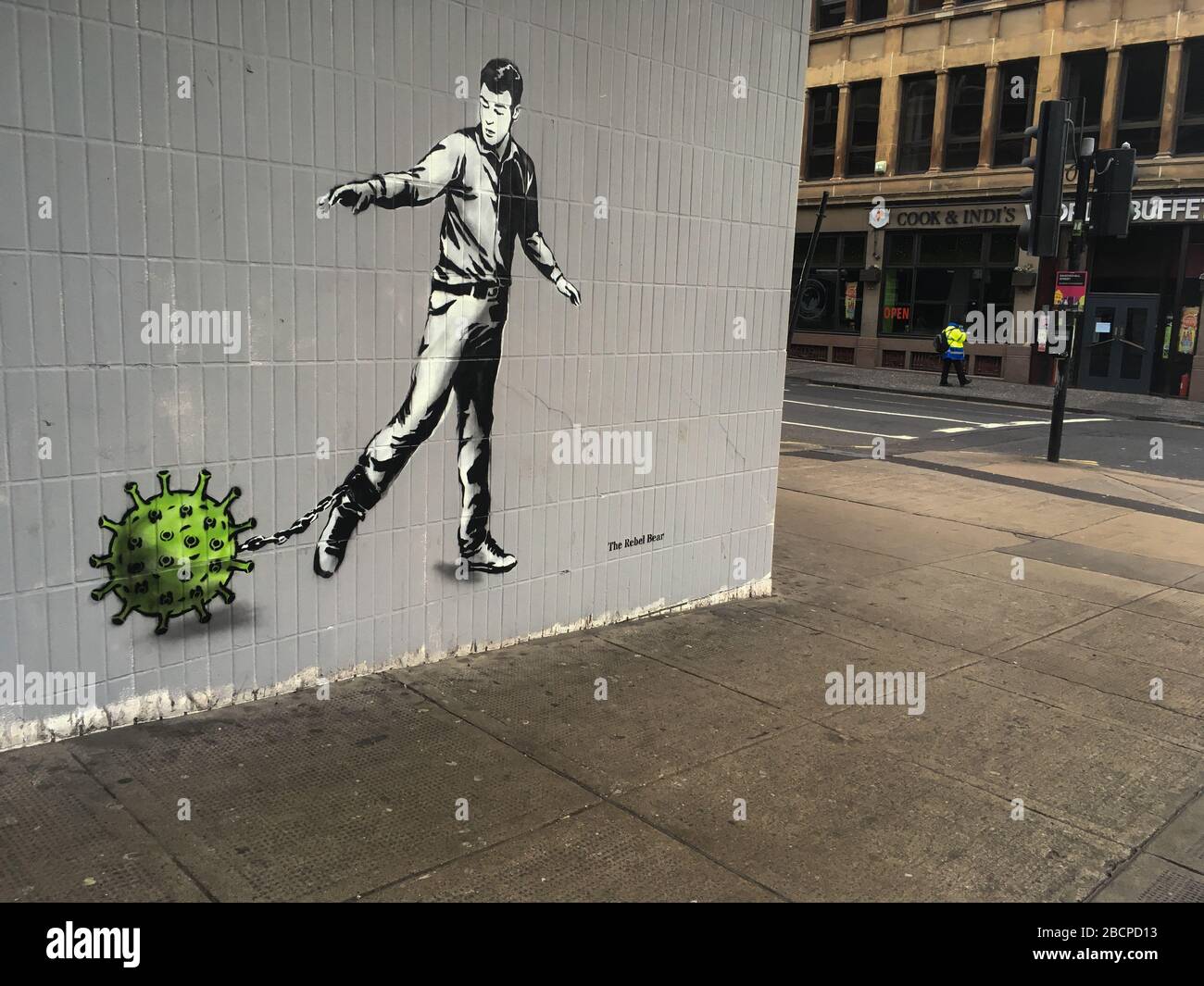 Glasgow, UK. 5th Apr, 2020. A new mural by the street artist The Rebel Bear depicting a man chained to a virus molecule, in empty streets in the city centre, illustrating that social distancing guidelines and 'stay at home' advisories are being adhered to in the time of Coronavirus COVID-19 pandemic crisis. Photo Credit: jeremy sutton-hibbert/Alamy Live News Stock Photo