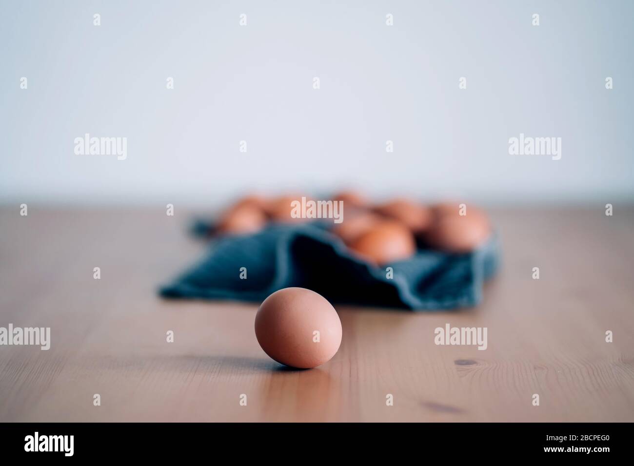 Raw chicken eggs on towel on wooden table. One fresh brown egg in the foreground. Organic food with high protein for good health, farm products. Selec Stock Photo