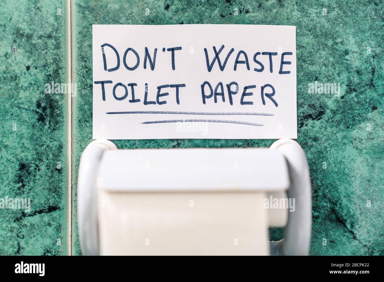 Don't waste toilet paper. Message on top of a roll of toilet paper for the coronavirus. Stock Photo