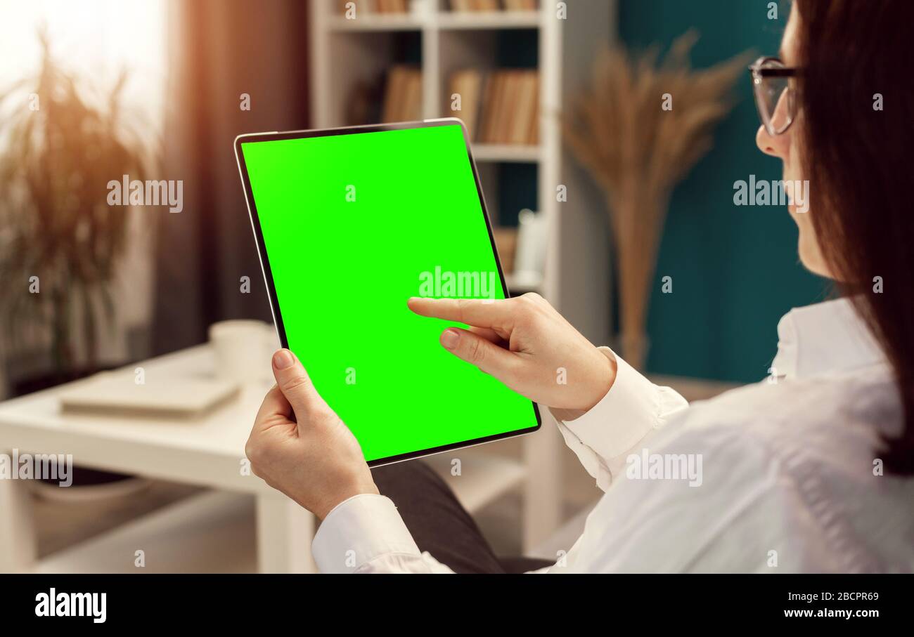 Female touching tablet green screen Stock Photo