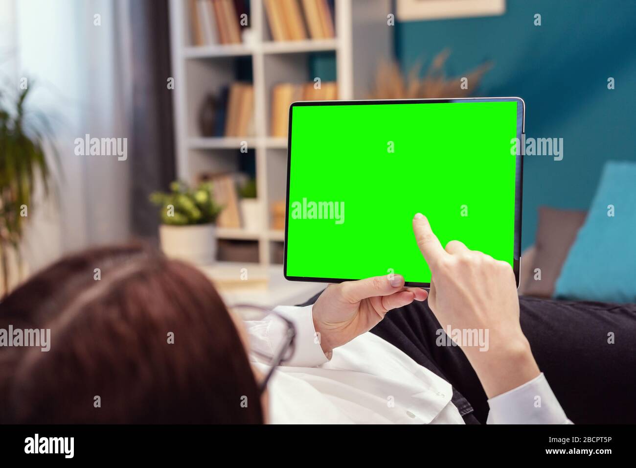 Person touching tablet green screen Stock Photo