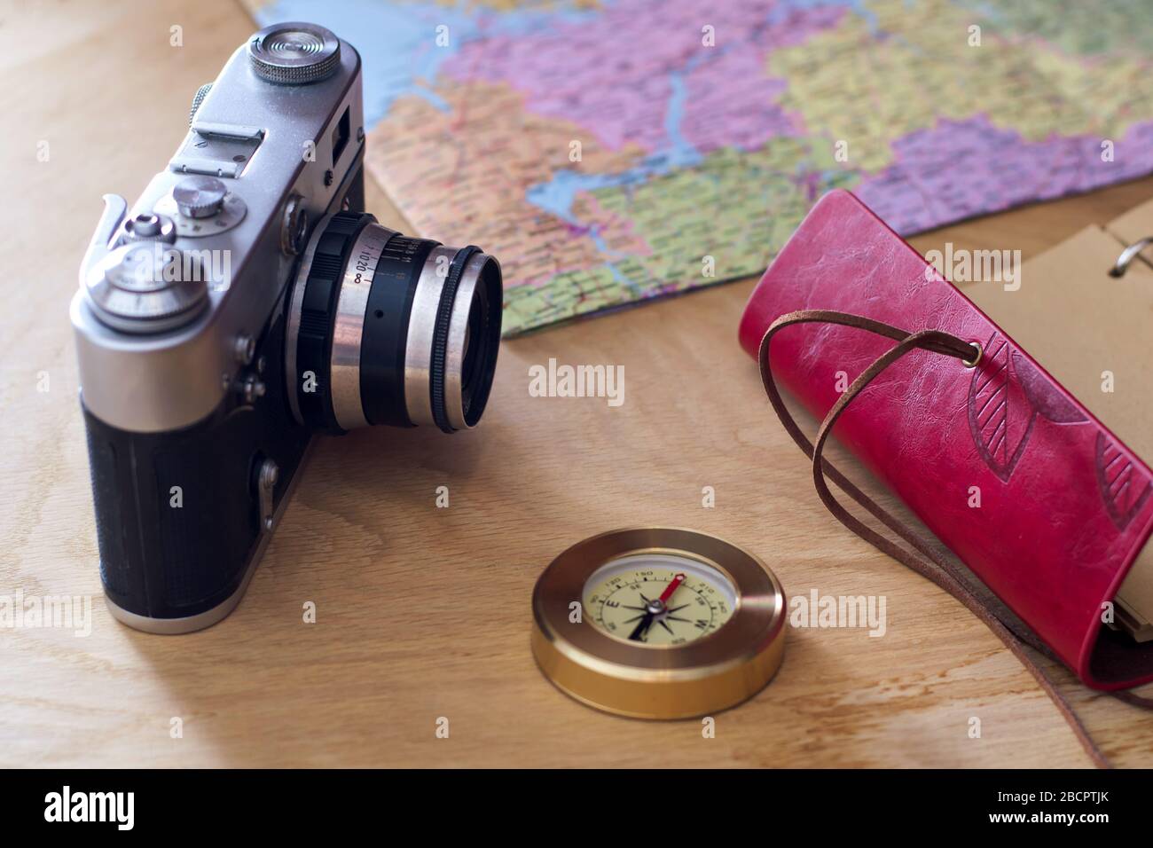 Traveler's things: camera, map, notebook, compass on a wooden ...