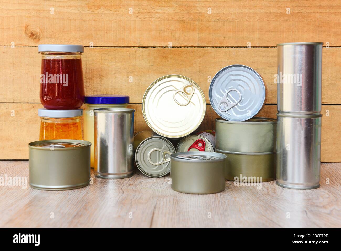 Various canned food in metal cans on wooden background / canned goods