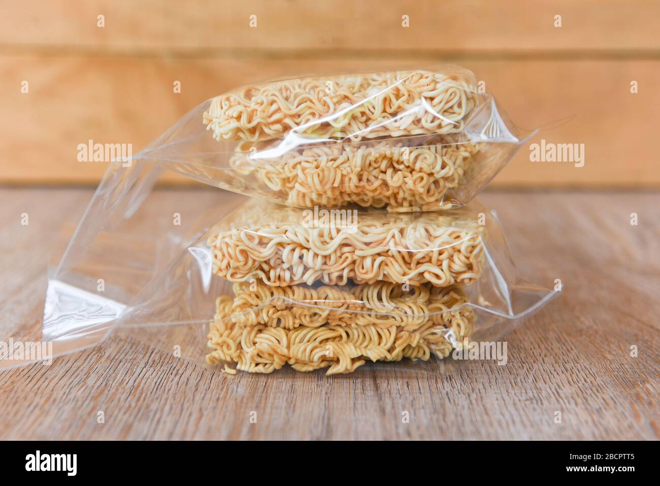 https://c8.alamy.com/comp/2BCPTT5/instant-noodles-in-package-on-wooden-background-dry-food-non-perishable-storage-goods-in-kitchen-home-or-for-donations-2BCPTT5.jpg