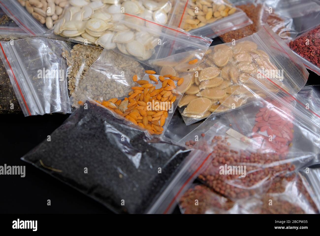 packaged in a variety of organic non-GMO seeds on a black background, Stock Photo