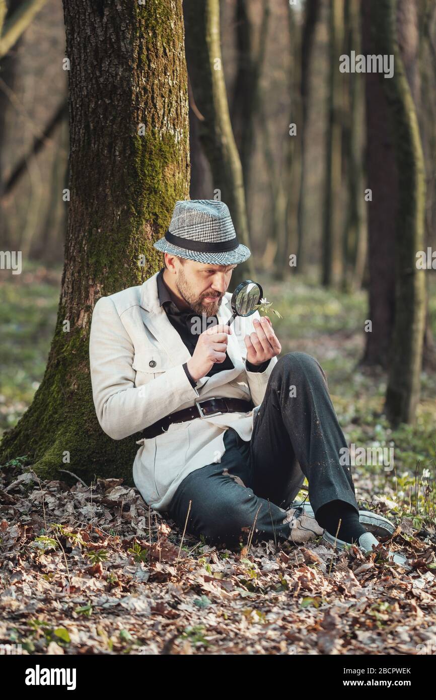Man closely looking at flower Stock Photo