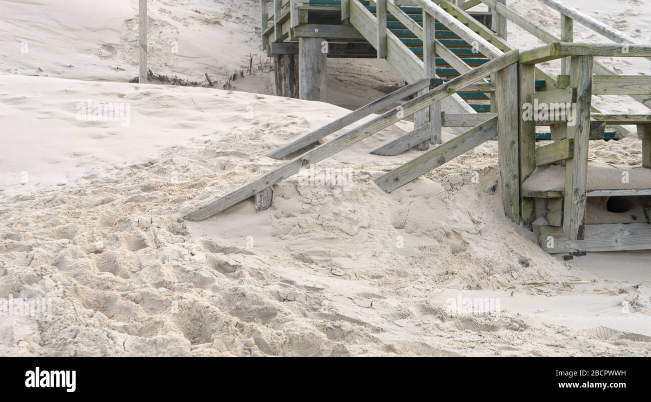 Wooden stairs on the beach are blown with sand Stock Photo